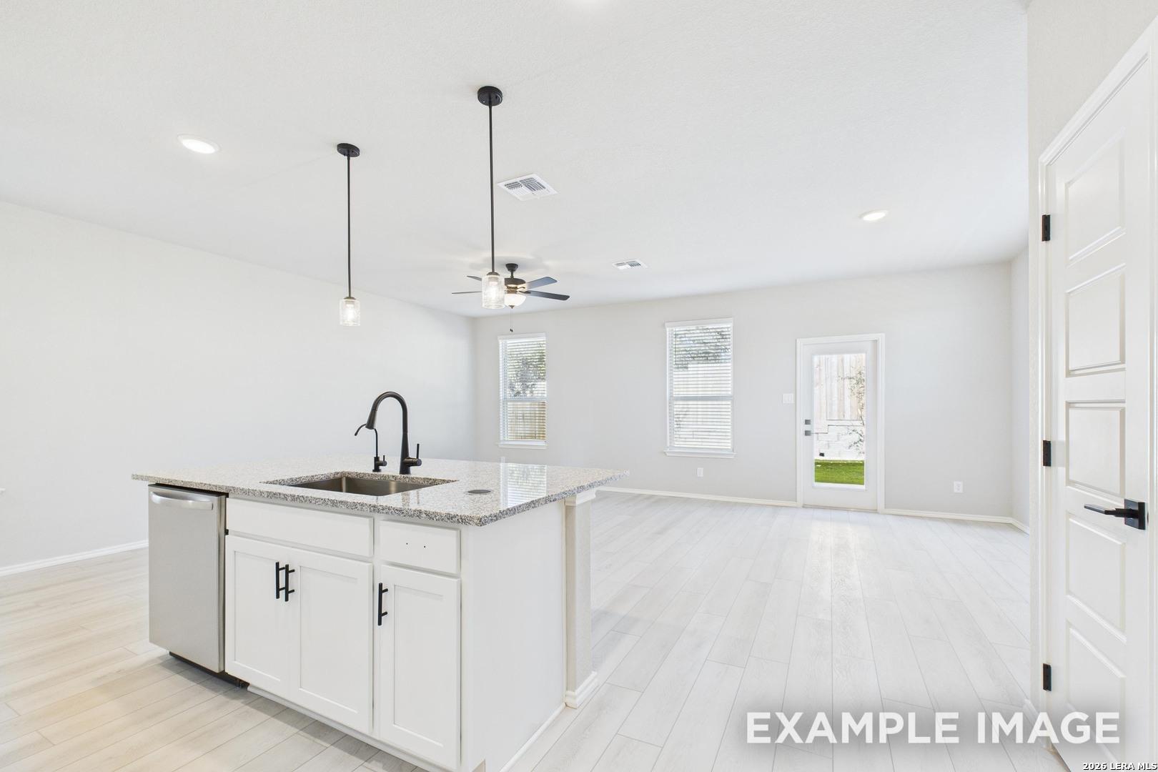 Bright open-concept kitchen island with granite countertops in The Charlotte B floor plan, Cedar Heights, San Antonio.