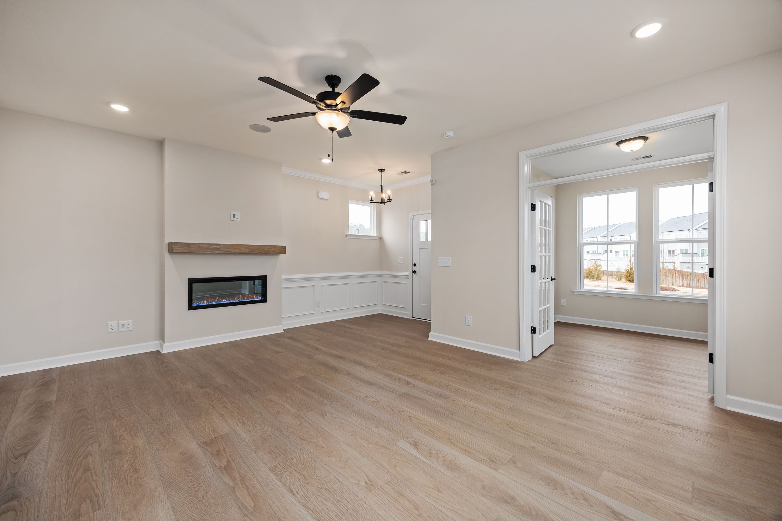 Spacious open-concept living room at Forestville Yard in Knightdale NC with hardwood floors, gas fireplace, and large windows