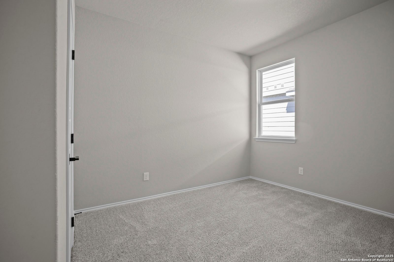 Bright secondary bedroom featuring gray walls, plush carpet, and sunlit window in The Asheville H by Davidson Homes, Converse, TX