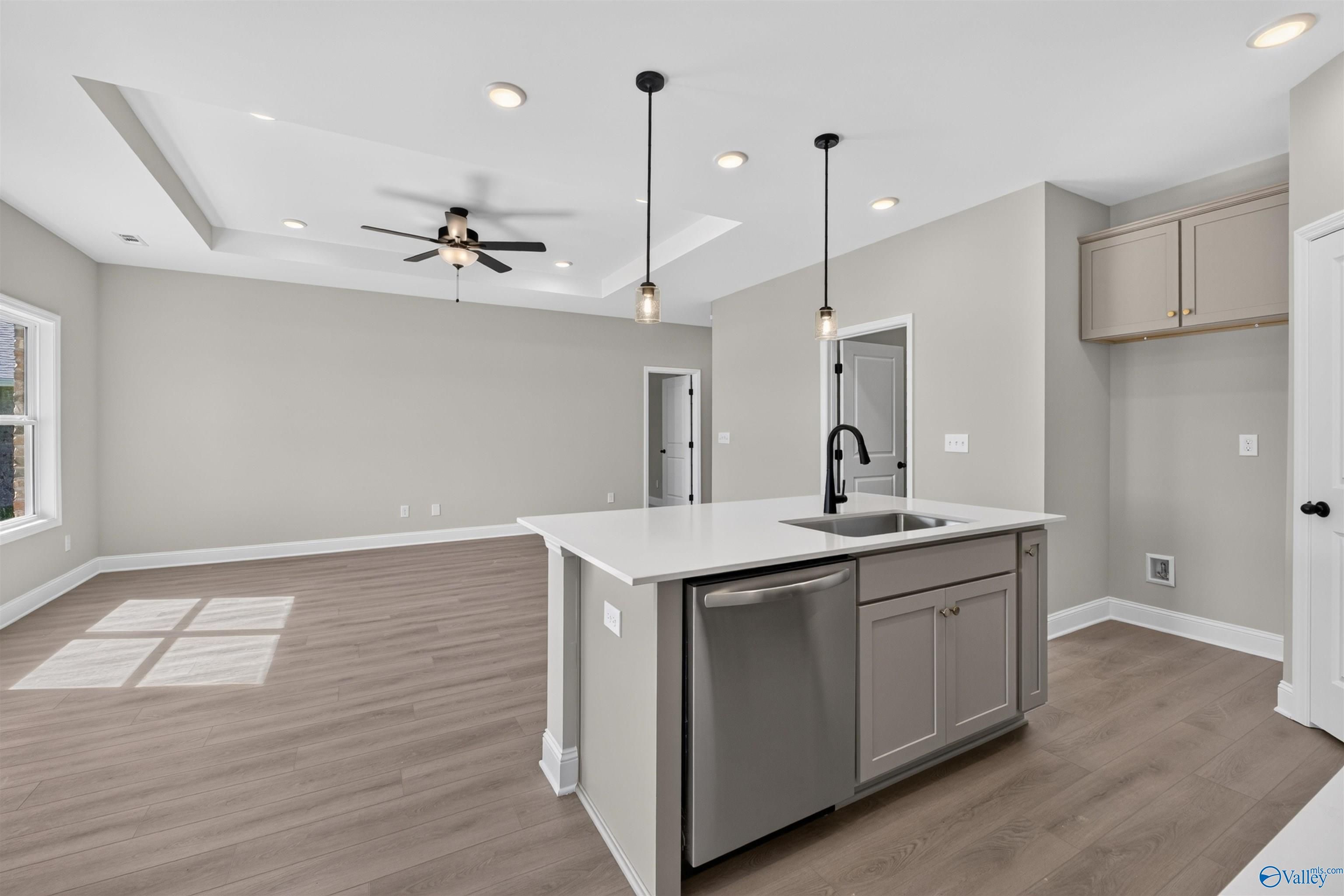 Open-concept kitchen with island, pendant lights, and stainless dishwasher in Davidson Homes The Butler floor plan, Hazel Green, Alabama