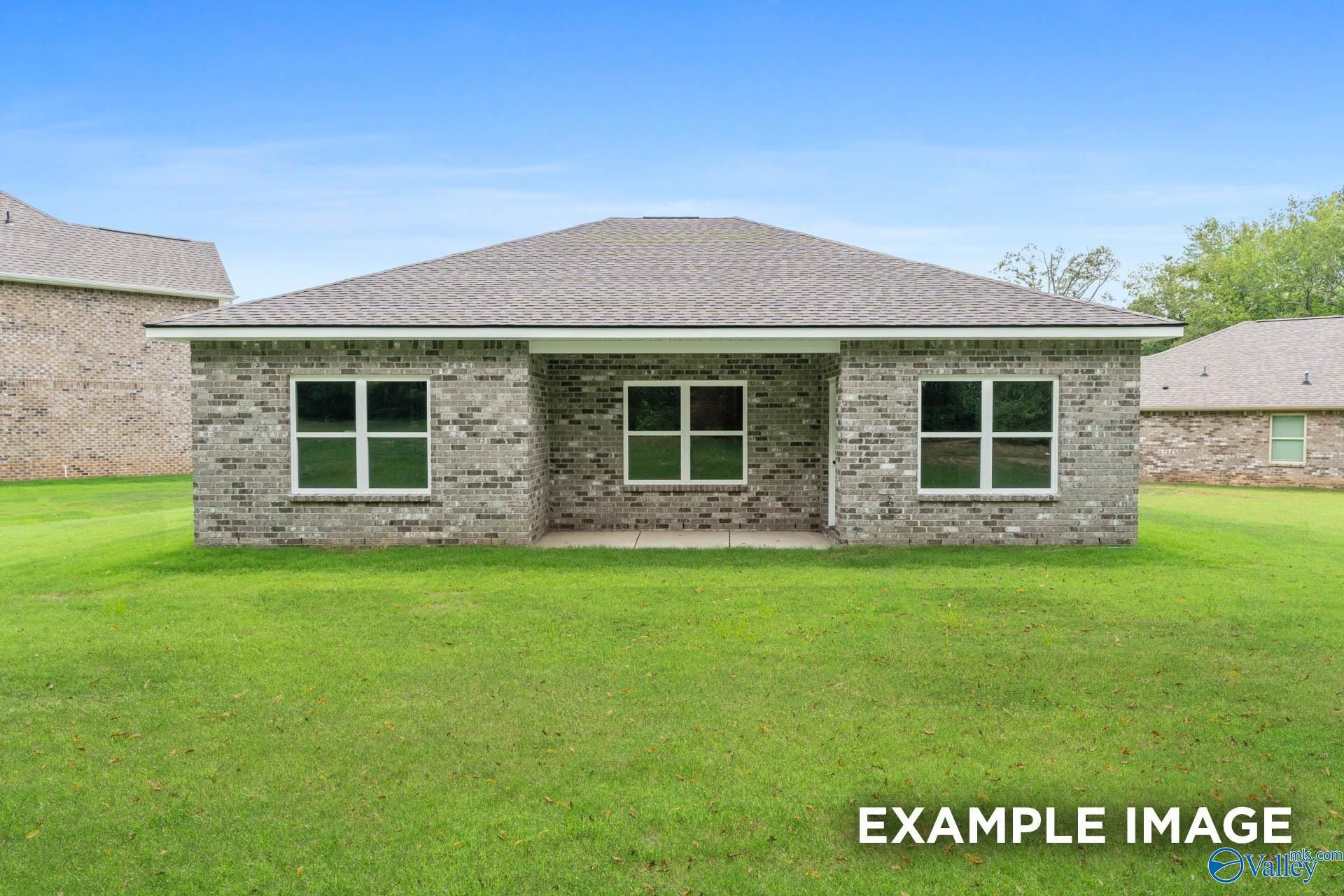 Single-story brick home with gabled roof, covered front porch, and double windows on green lawn in Clearview, Hazel Green, Alabama