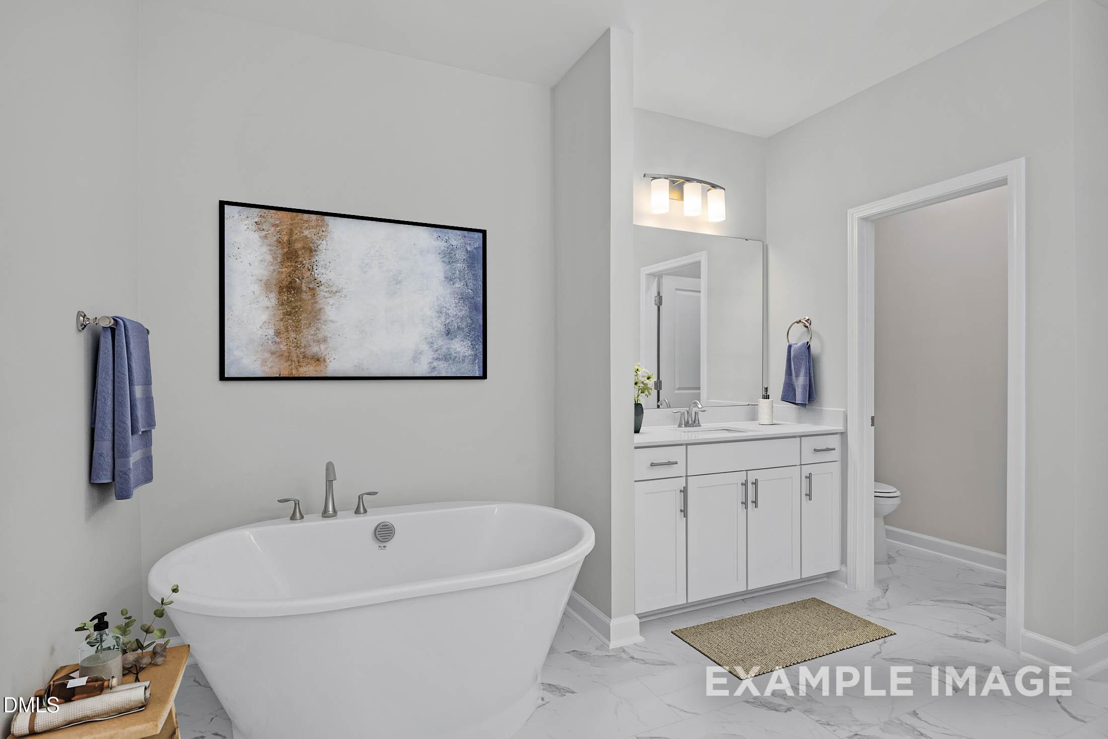 Modern bathroom with freestanding tub, white vanity, and marble-style flooring in The Aspen C home at Ashland, Apex, NC.