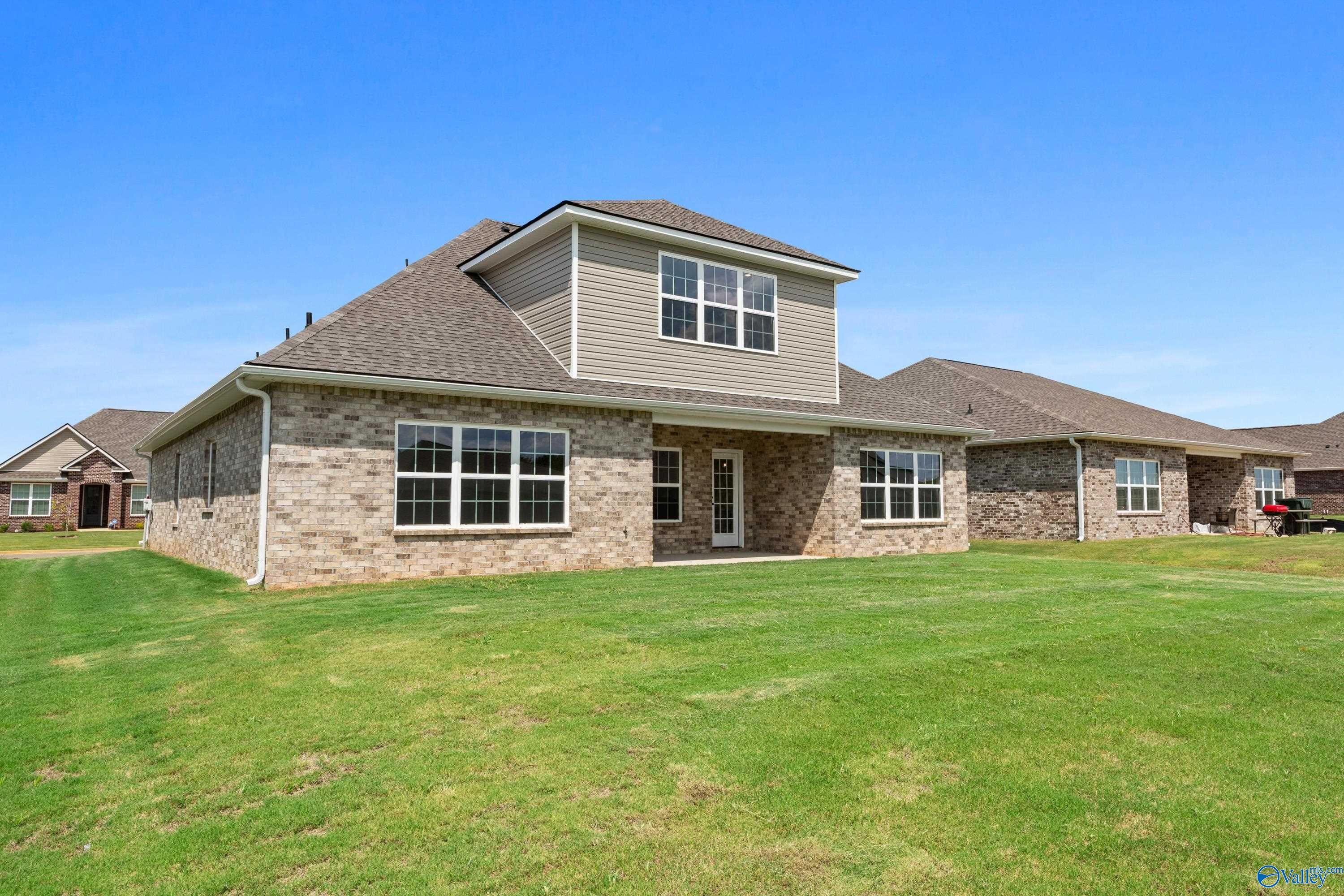 Exterior of The Montgomery B With Bonus 1.5-story home: brick and siding facade, 2-car garage, green lawn in Kendall Downs, Toney, Alabama