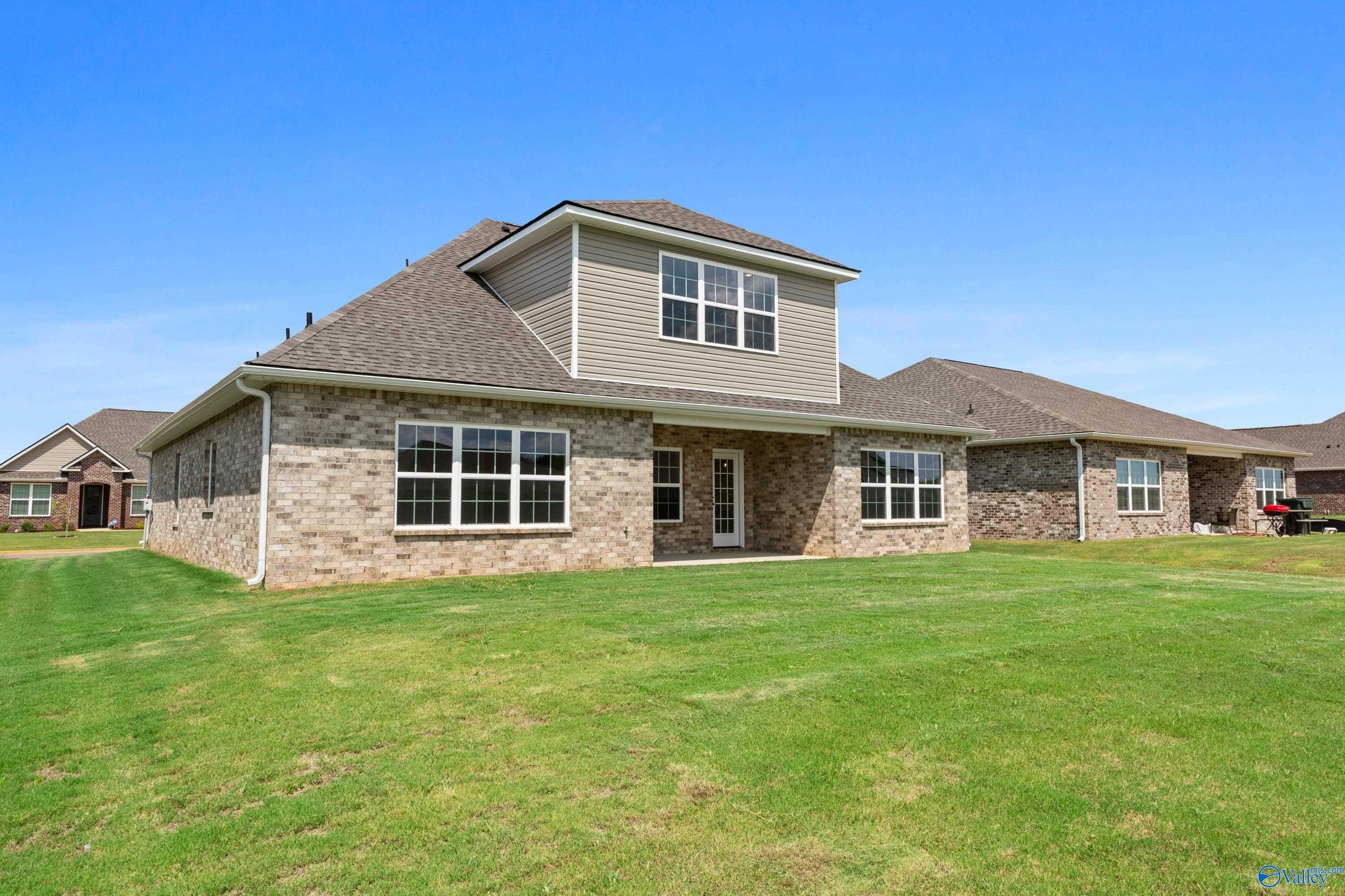 Exterior of The Montgomery B With Bonus 1.5-story home: brick and siding facade, 2-car garage, green lawn in Kendall Downs, Toney, Alabama