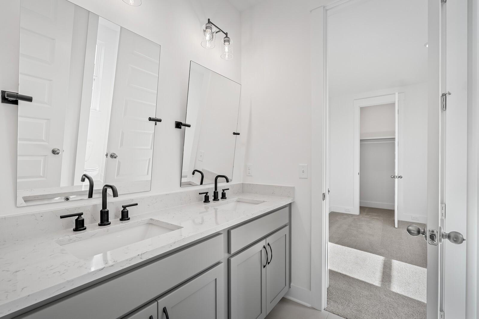 Modern double vanity with quartz counters, black faucets, and mirrors in The Alston A bathroom, Davidson Homes, Murfreesboro, TN