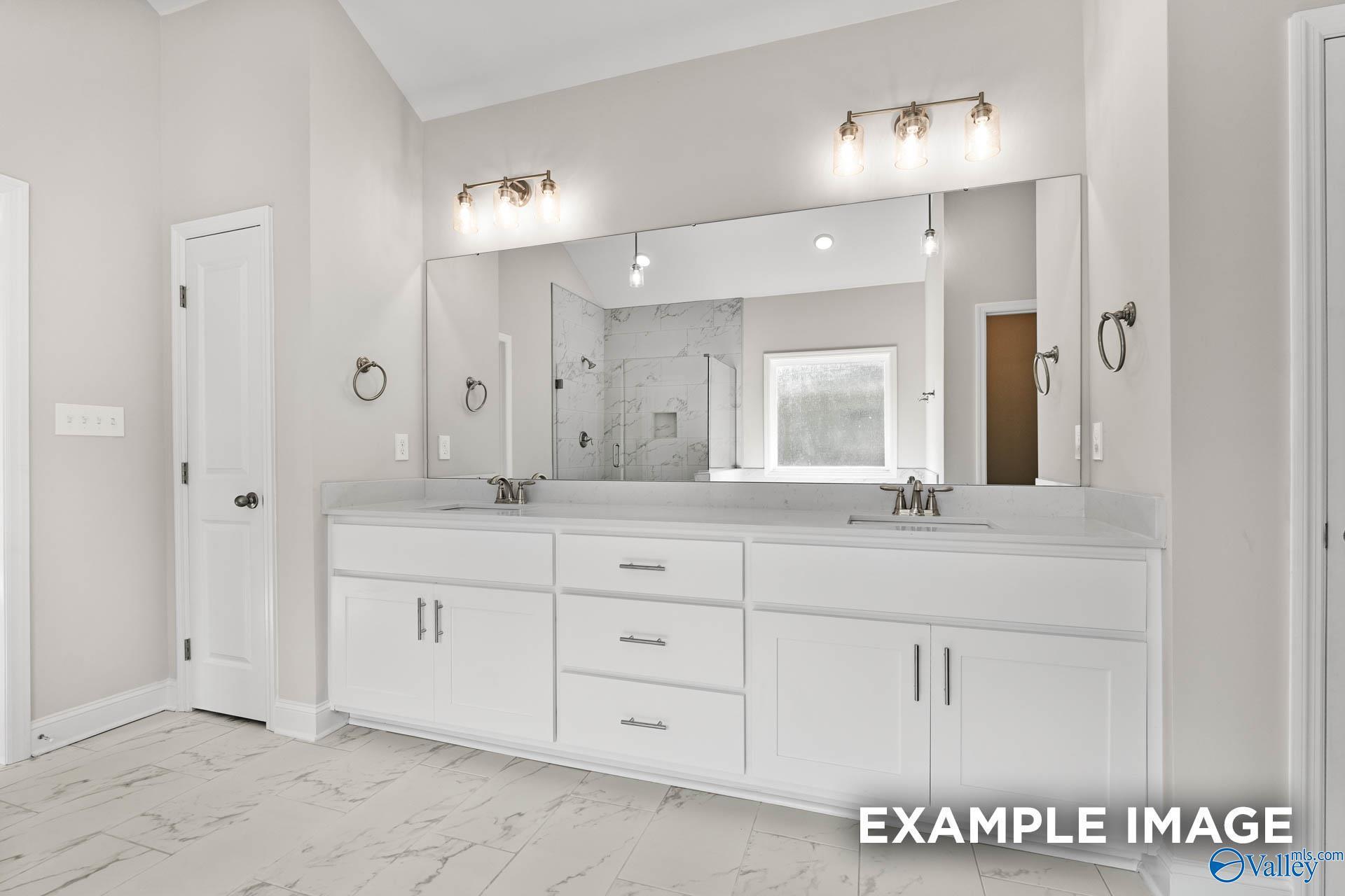 Modern master bathroom with double vanity, white shaker cabinets, and frameless shower in Davidson Homes The Finleigh, Huntsville, AL