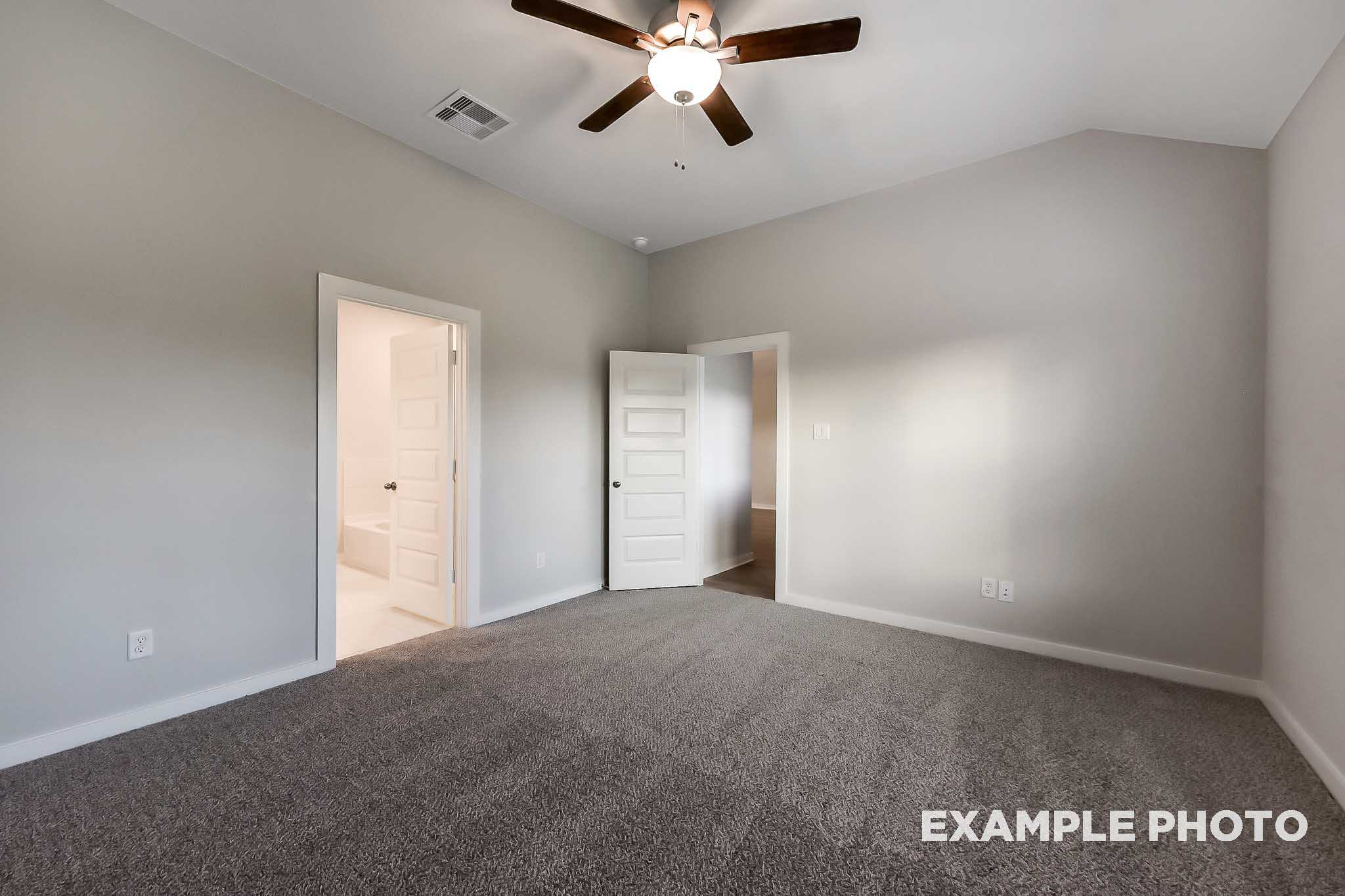 Spacious secondary bedroom in The Laguna B with light gray walls, vaulted ceiling fan, carpeted floor, and bathroom access