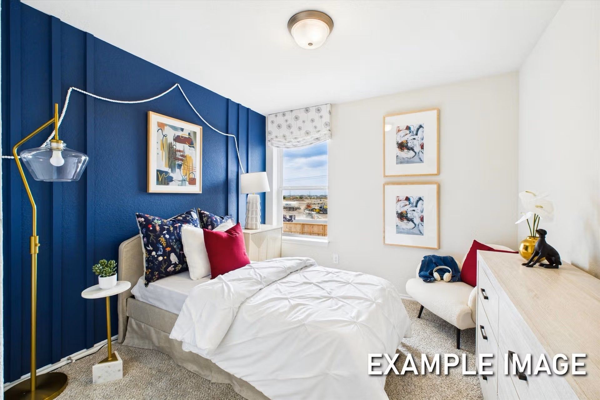 Bedroom with bold blue accent wall and modern decor in The Brazos E floor plan by Davidson Homes in Heartland, Texas.