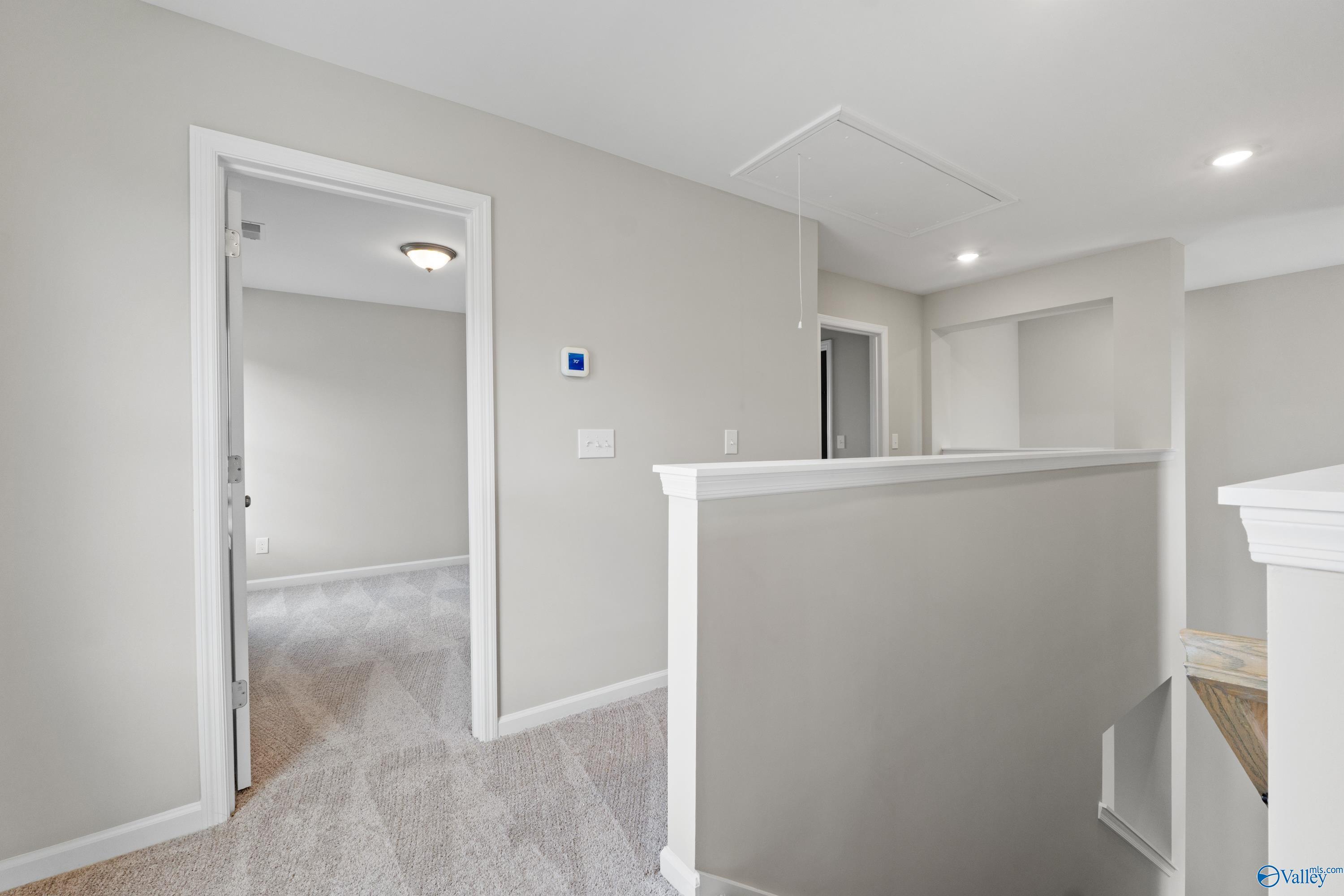 Upstairs loft overlook with beige walls, carpeted flooring, and railing in Davidson Homes The Augusta, Madison, Alabama