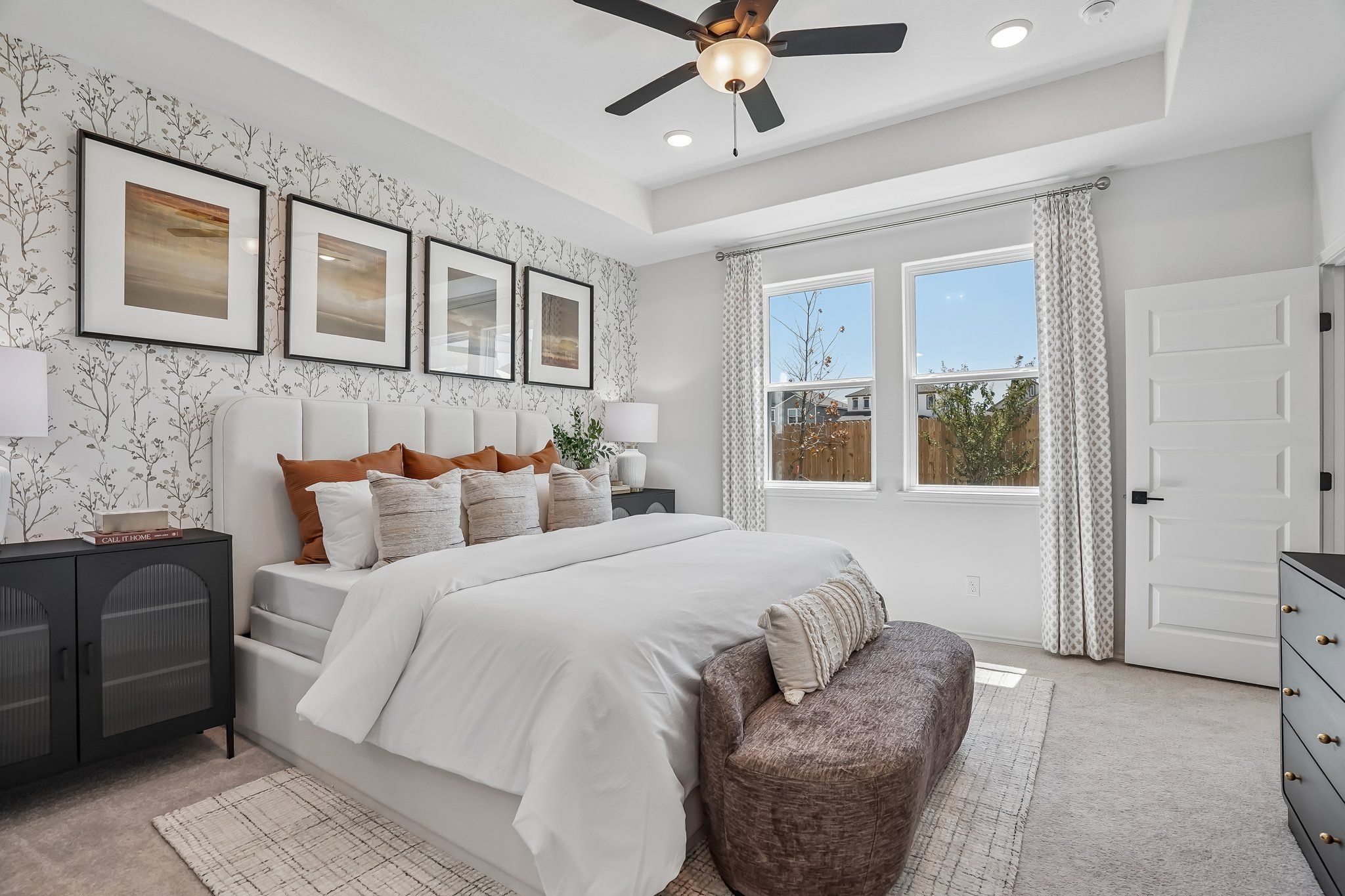Spacious bedroom with tray ceiling and floral wallpaper at Fairway Crossing in Converse, Texas by Davidson Homes.