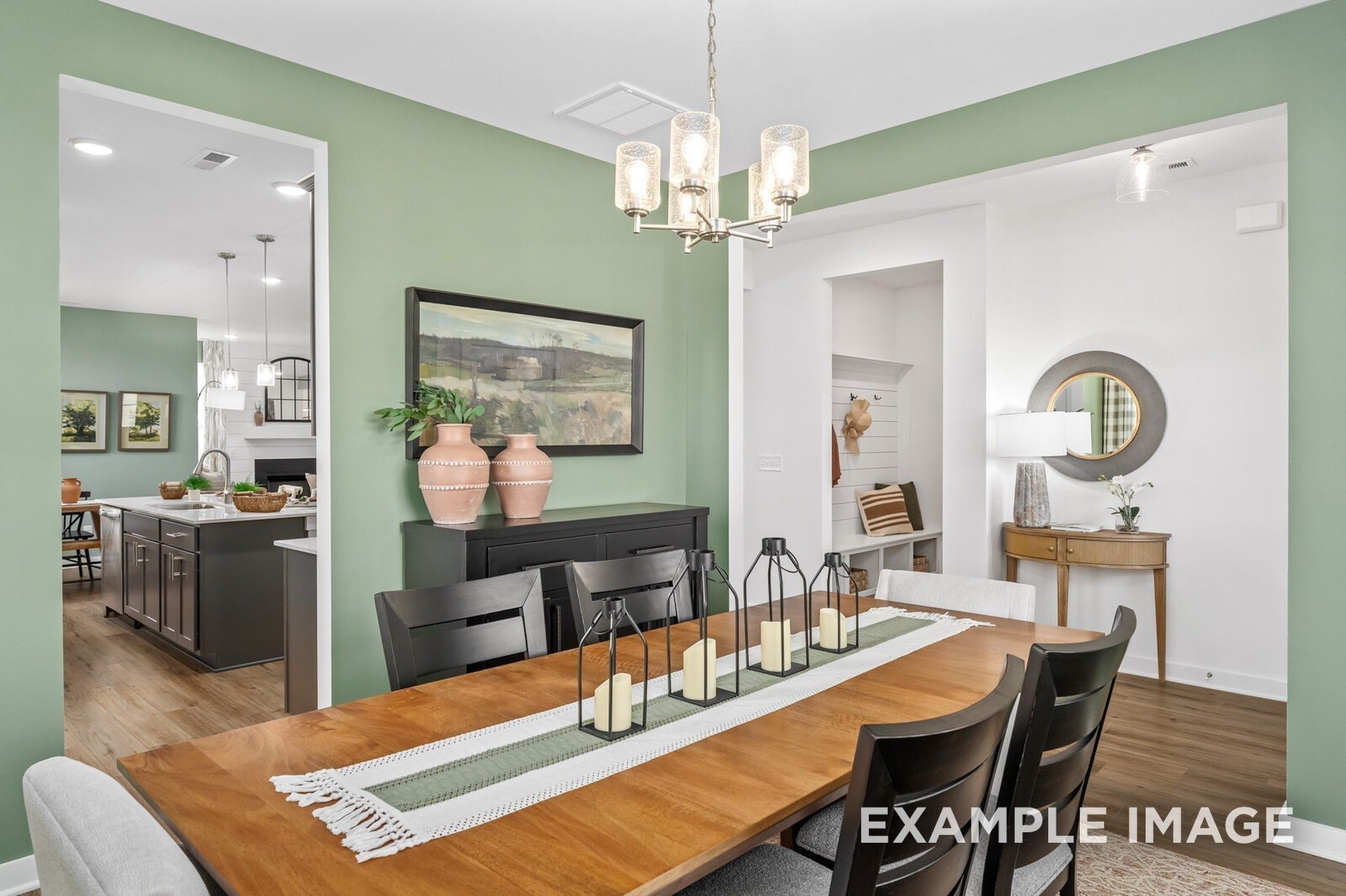 Elegant dining room with emerald green walls, wooden table, chandelier, and open kitchen view in Davidson Homes The Ash A, Gallatin, TN