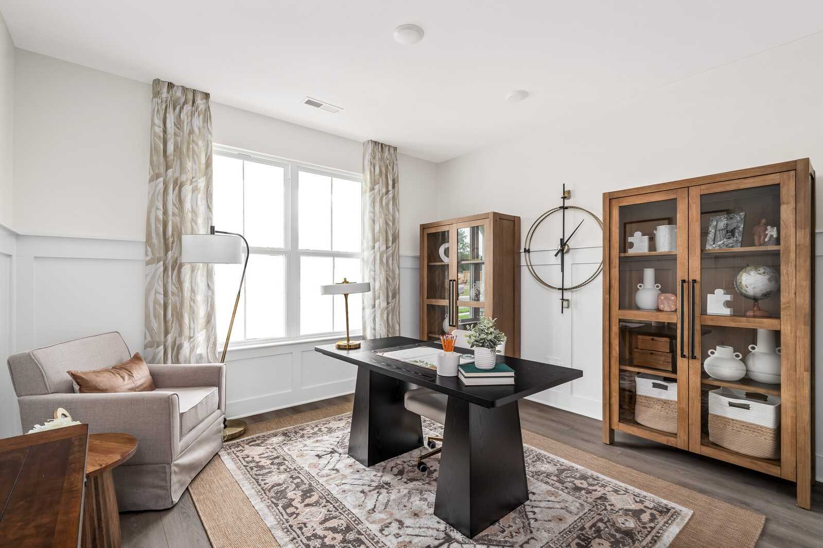 Cozy home office at Woods Crossing in Gallatin TN with black desk, wooden bookshelves, arc lamp, and patterned rug