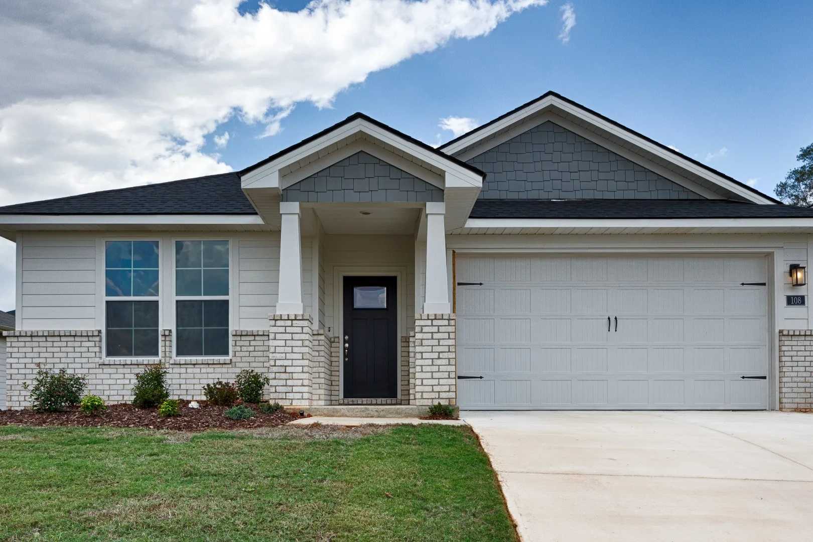 Contemporary ranch home exterior at Bailey Park in Fayetteville TN with white brick, gabled roof, covered porch, and two-car garage