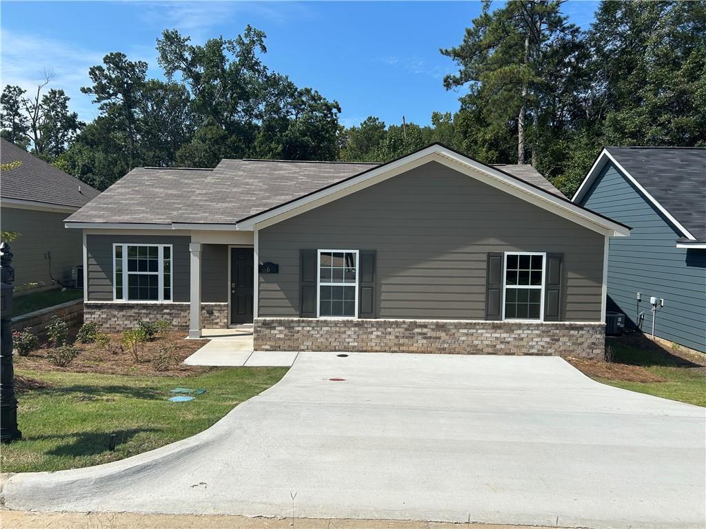 Modern gray single-story 3-bedroom home with brick accents, front porch, and driveway in Summer Vineyard, Phenix City, Alabama by Davidson Homes