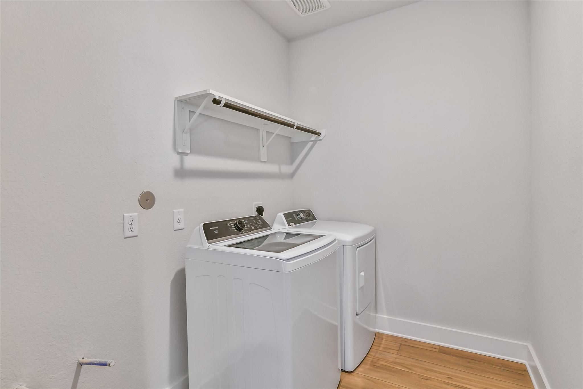 Spacious laundry room featuring white Whirlpool washer, dryer, and built-in shelves in 4-bedroom Davidson Homes The Victoria A, Lago Mar, Texas City