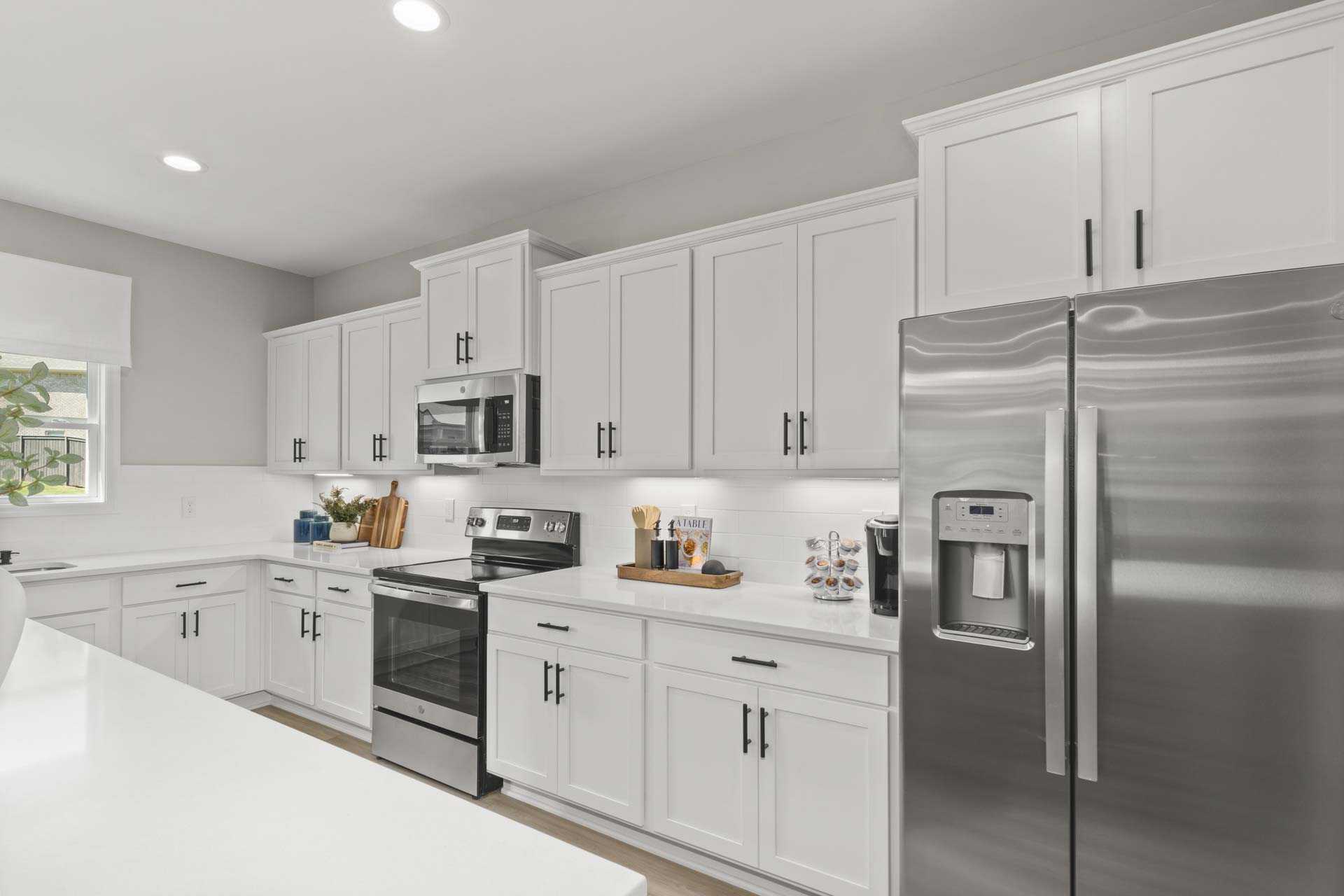 Spacious modern kitchen at Creek Grove in New Market Alabama with white shaker cabinets, stainless steel appliances, and large island