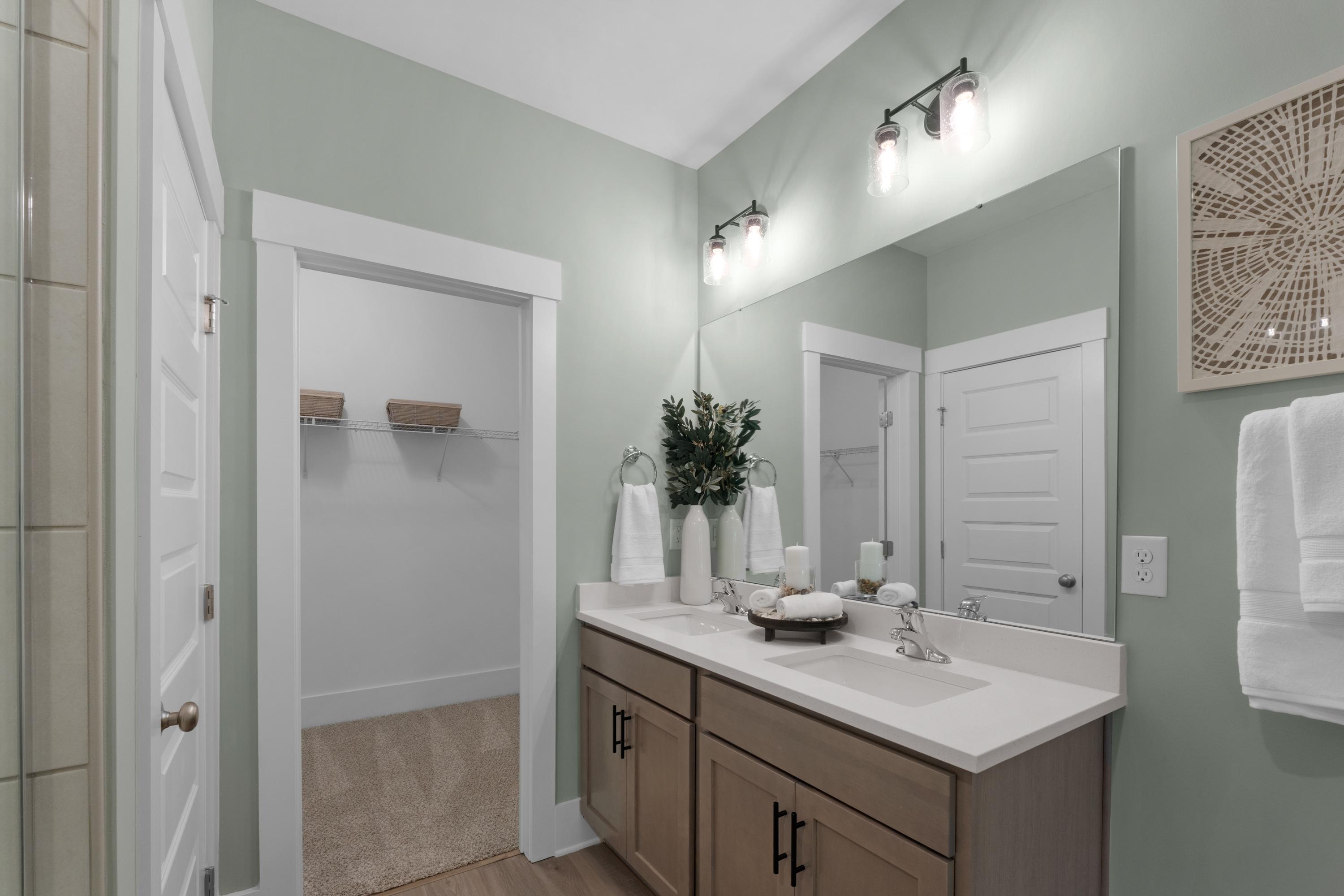 Spacious primary bathroom at Hollon Meadow in Decatur Alabama with sage green walls double vanity and walk-in closet