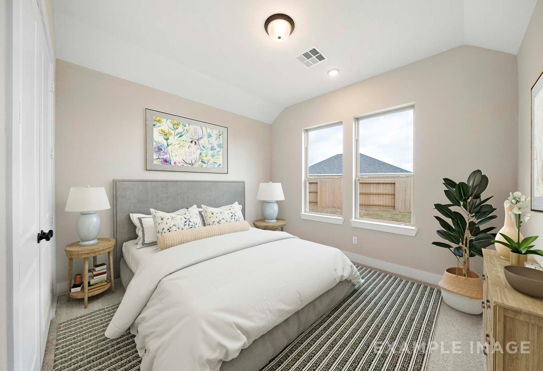 Spacious master bedroom in The Elizabeth A with king bed, beige walls, large windows, and potted plants