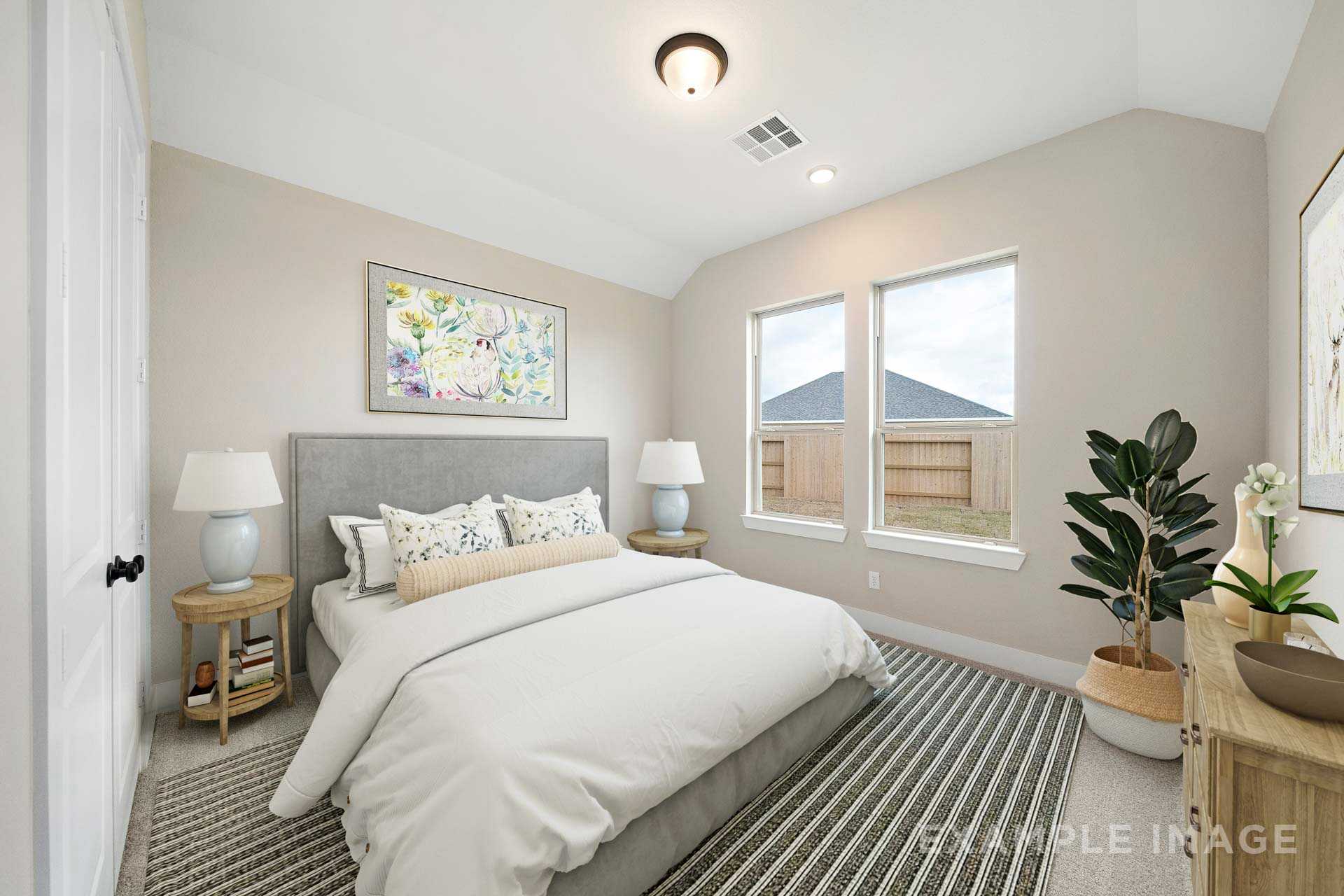 Spacious master bedroom in The Elizabeth A with king bed, beige walls, large windows, and potted plants