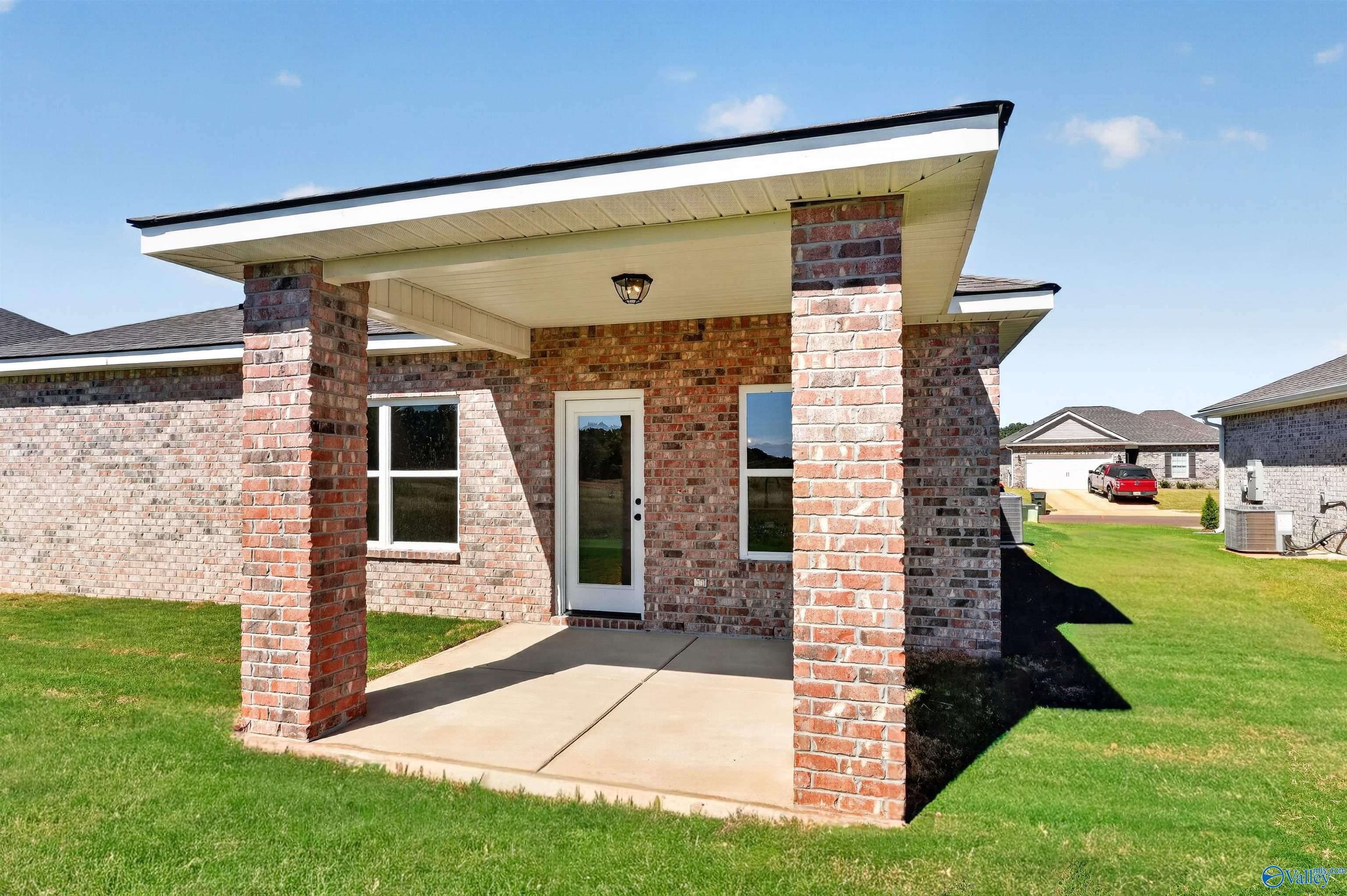 Covered brick porch with white door on Davidson Homes The Butler single-story home in Clearview, Hazel Green, Alabama.