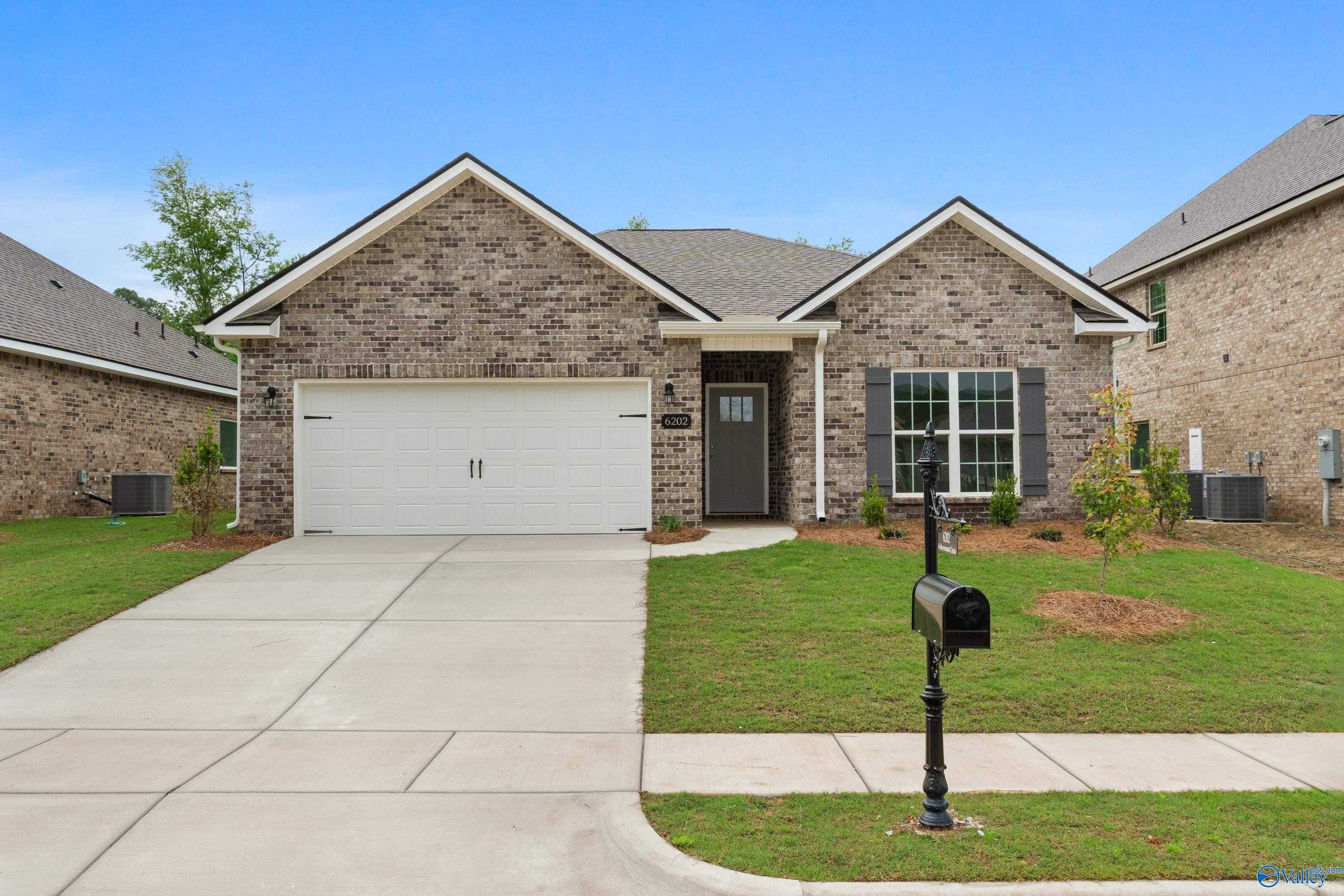 Modern brick 1-story home with 2-car garage, driveway, and lush lawn in Jaguar Hills, Huntsville, Alabama - Davidson Homes Asheville C