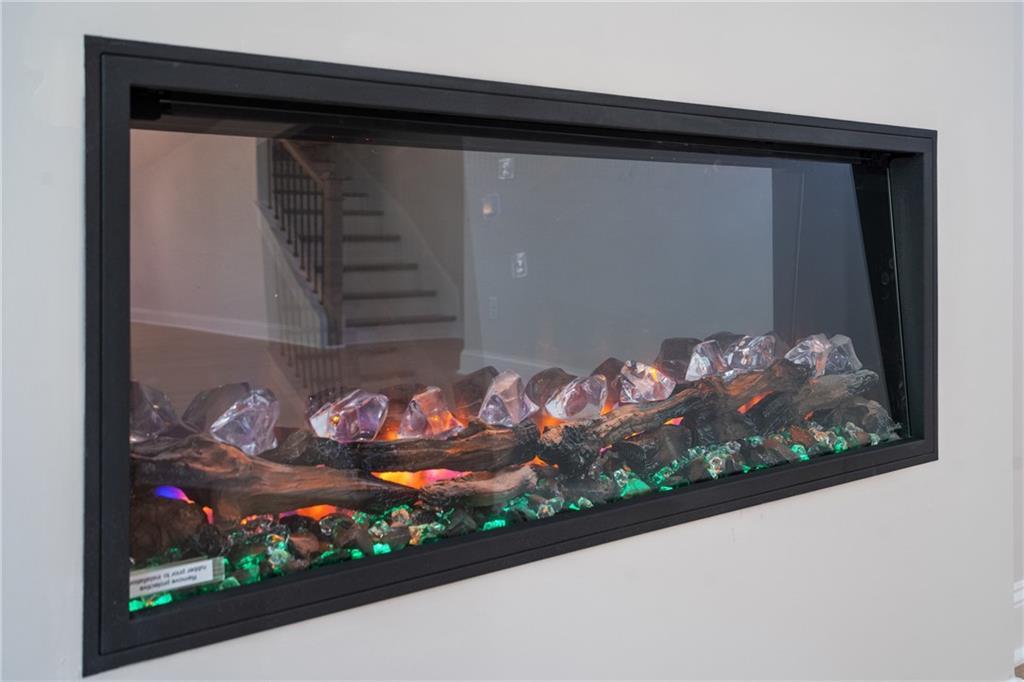 Modern linear electric fireplace with colorful crystal flames and LED accents in Davidson Homes The Hickory E, Buford, GA