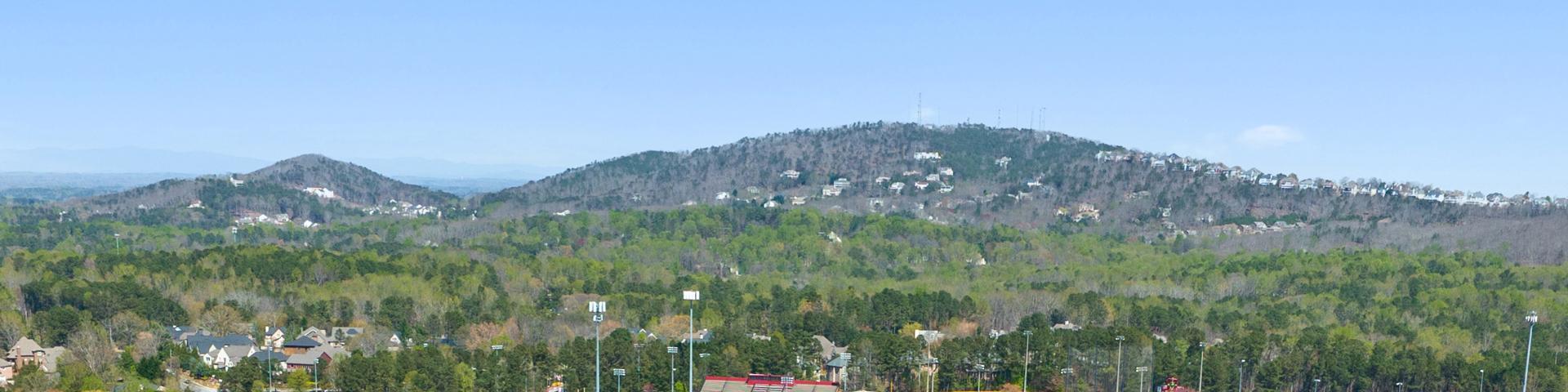 Panoramic view of rolling hills, lush forests, tennis courts and homes at Lassiter Place in East Cobb, Georgia