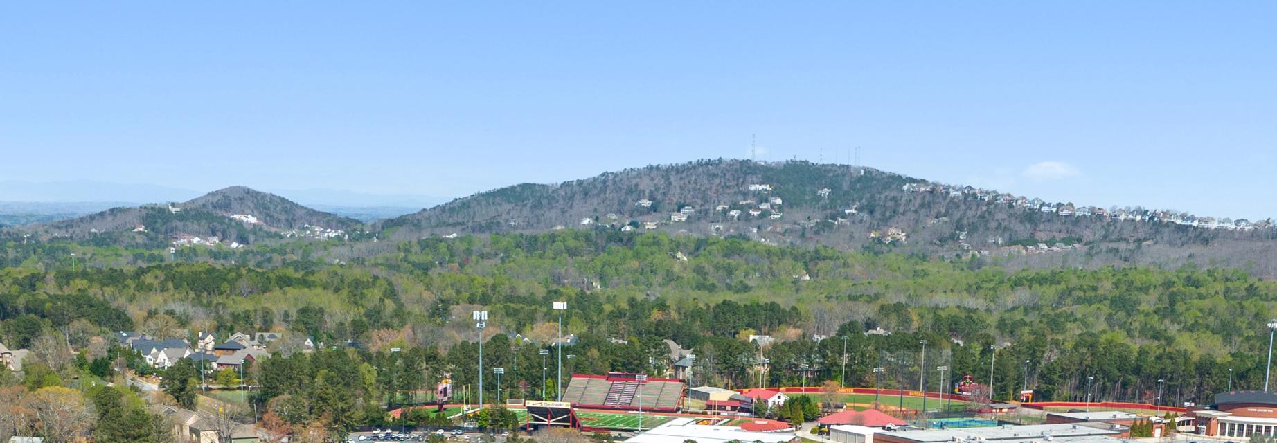 Panoramic view of rolling hills, lush forests, tennis courts and homes at Lassiter Place in East Cobb, Georgia