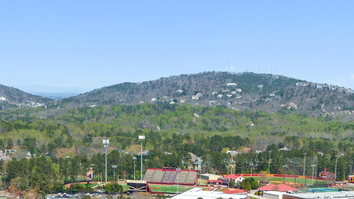 Panoramic view of rolling hills, lush forests, tennis courts and homes at Lassiter Place in East Cobb, Georgia