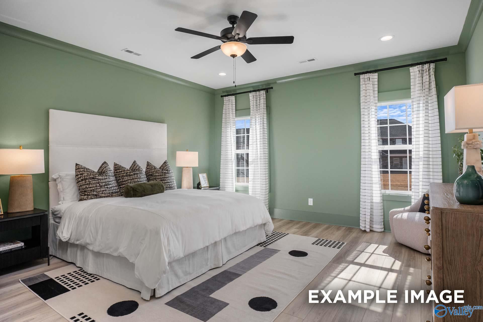 Elegant secondary bedroom with sage green walls, king bed, and ceiling fans in Davidson Homes The Rockford B, Madison AL