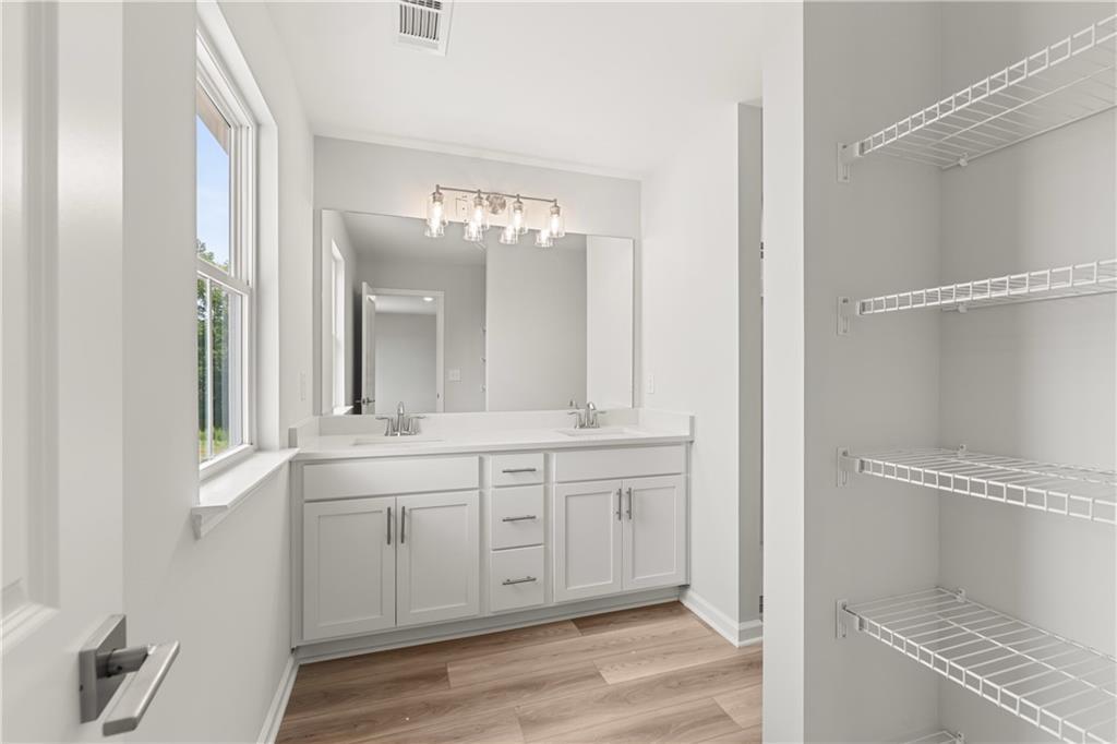 Modern double vanity bathroom with wire shelving in The Russell A floor plan at Cedar Farms, Winder, Georgia.