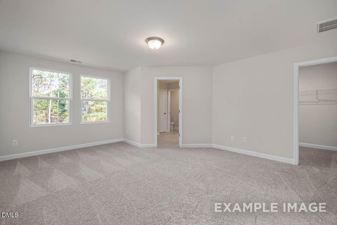 Bright master bedroom with en-suite bath access and closet in Davidson Homes The Graham, Springvale, Fuquay-Varina, NC
