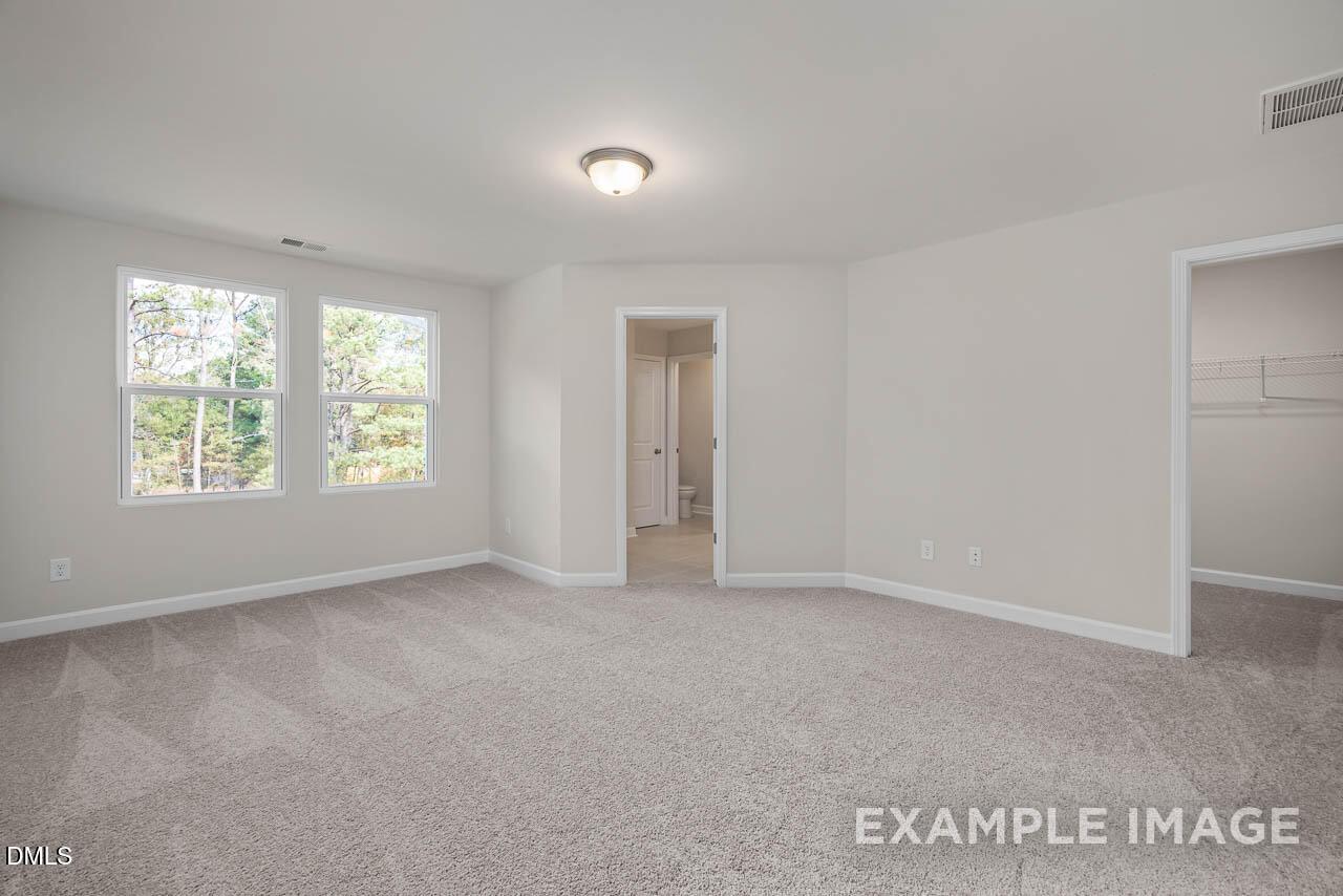 Bright master bedroom with en-suite bath access and closet in Davidson Homes The Graham, Springvale, Fuquay-Varina, NC