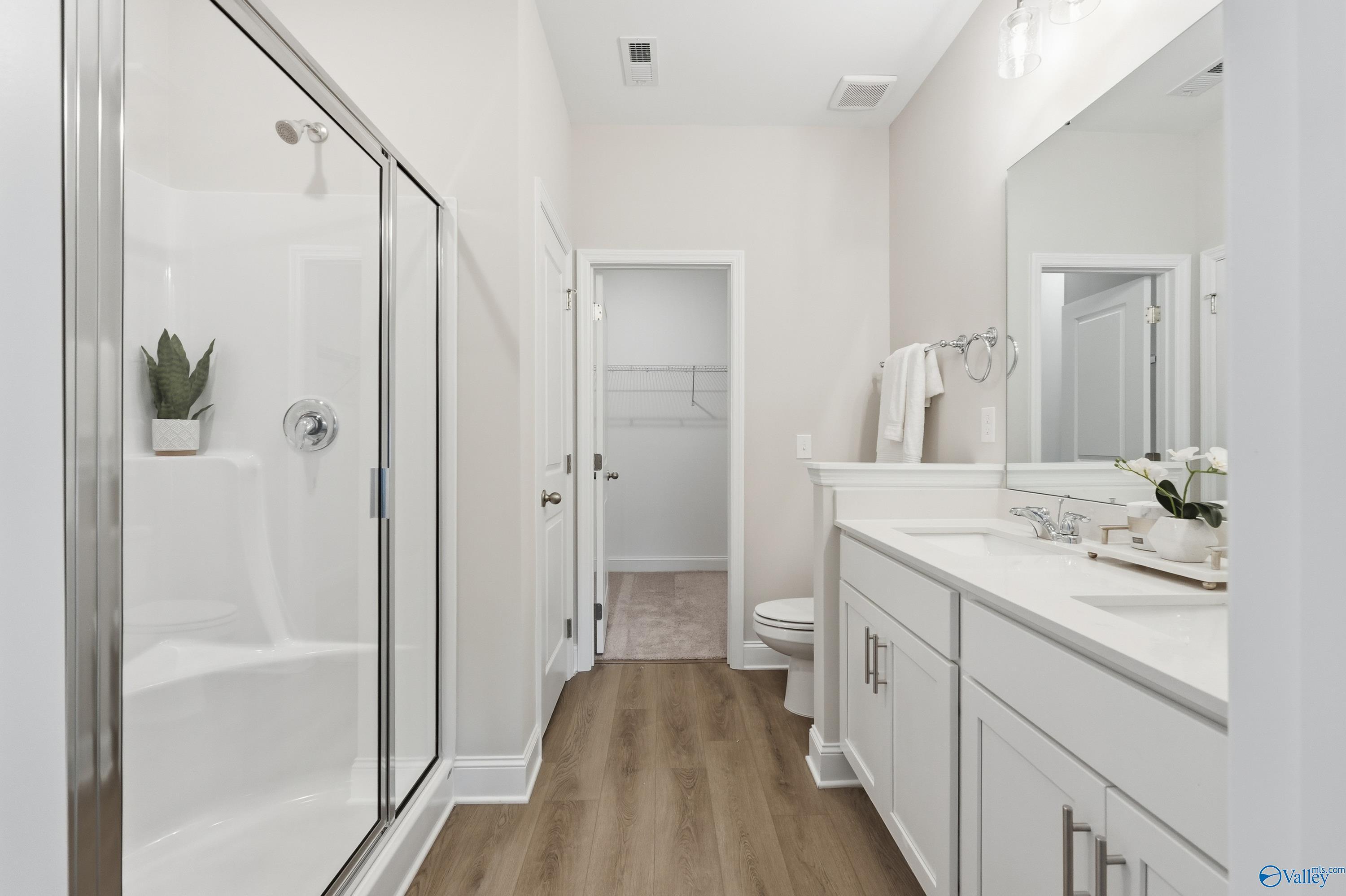 Modern master bathroom with frameless glass shower, double vanity, and luxury finishes in Davidson Homes The Asheville, Toney, Alabama