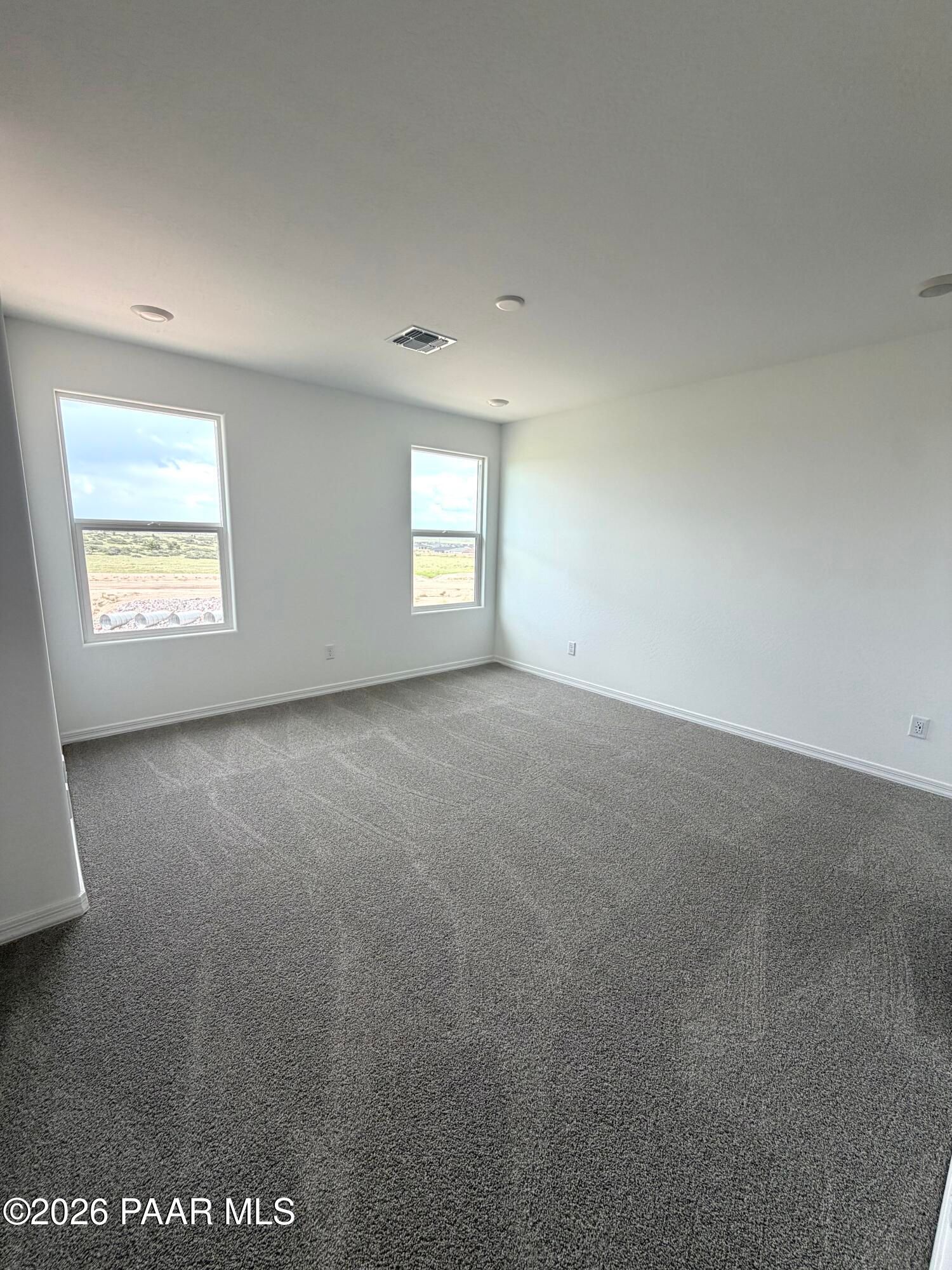 Spacious, carpeted bedroom with natural light in The Raleigh A floor plan at South Ranch, Prescott, Arizona.