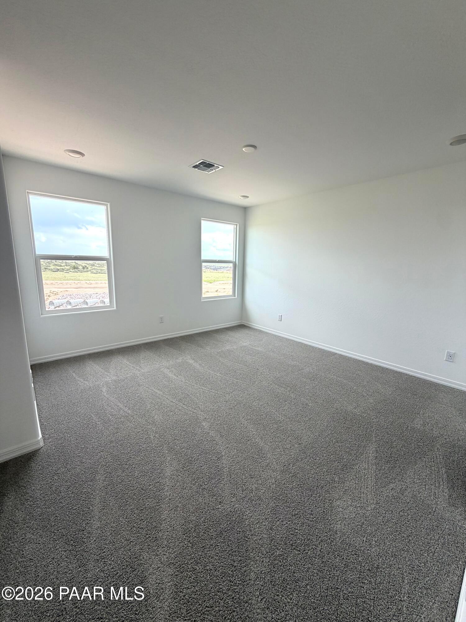 Spacious, carpeted bedroom with natural light in The Raleigh A floor plan at South Ranch, Prescott, Arizona.
