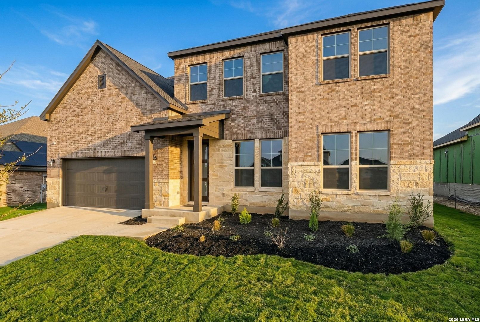 Two-story brick and stone exterior of The Belmont G floor plan by Davidson Homes in The Reserve at Potranco Oaks, TX.