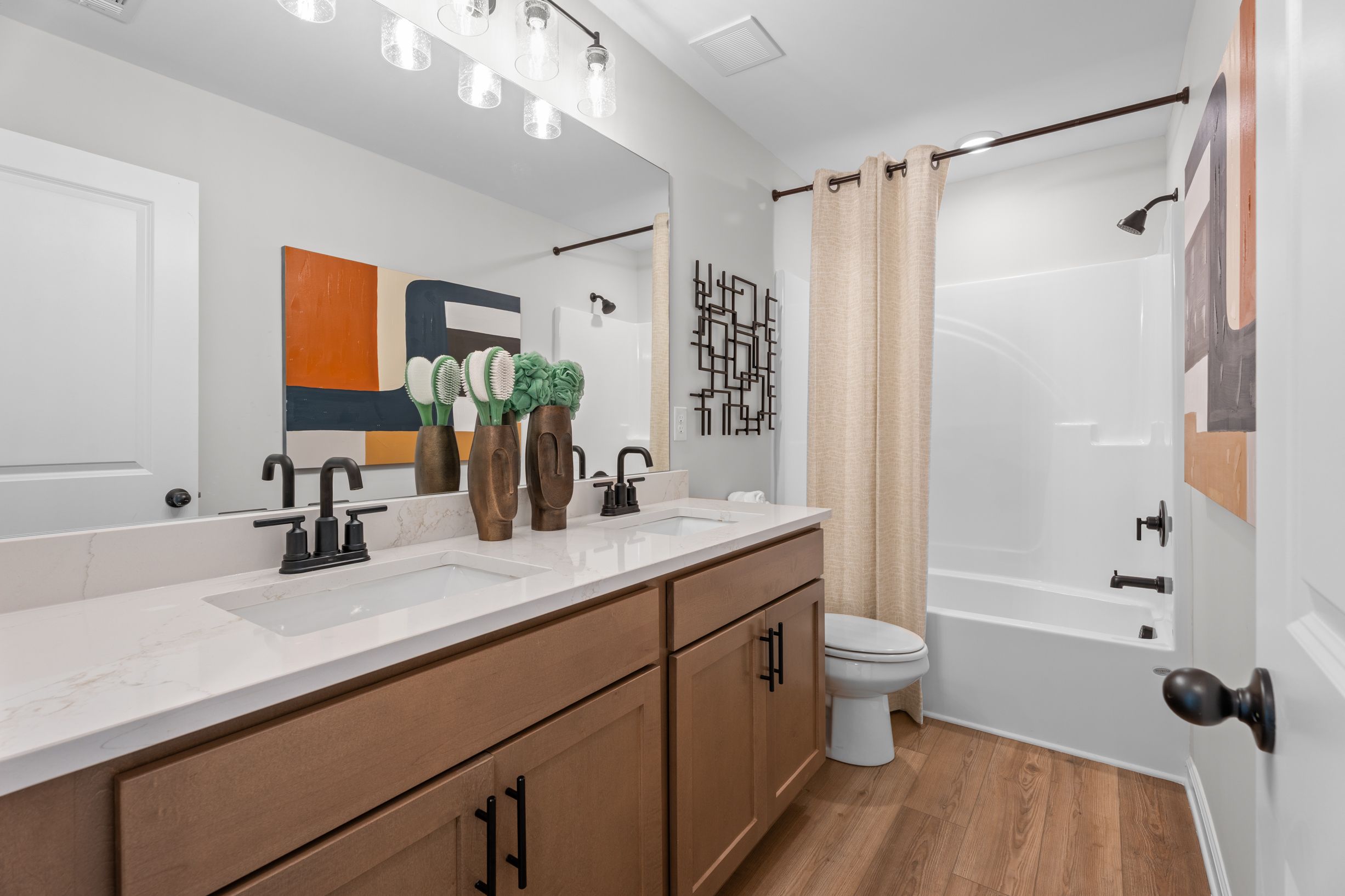 Modern bathroom with dual vanity, quartz countertops, and matte black fixtures at Links Crossing in Auburn, Alabama.