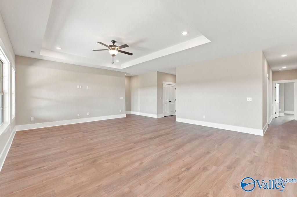 Spacious open-concept living room with tray ceiling in The Rockford floor plan at Cain Park, Hartselle, Alabama.