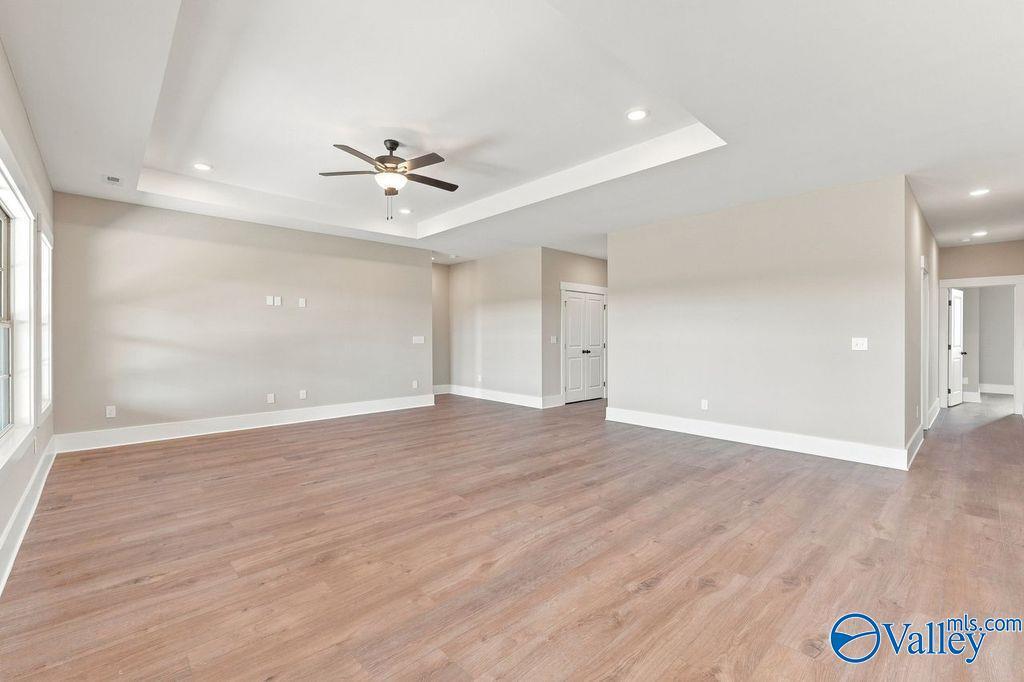 Spacious open-concept living room with tray ceiling in The Rockford floor plan at Cain Park, Hartselle, Alabama.
