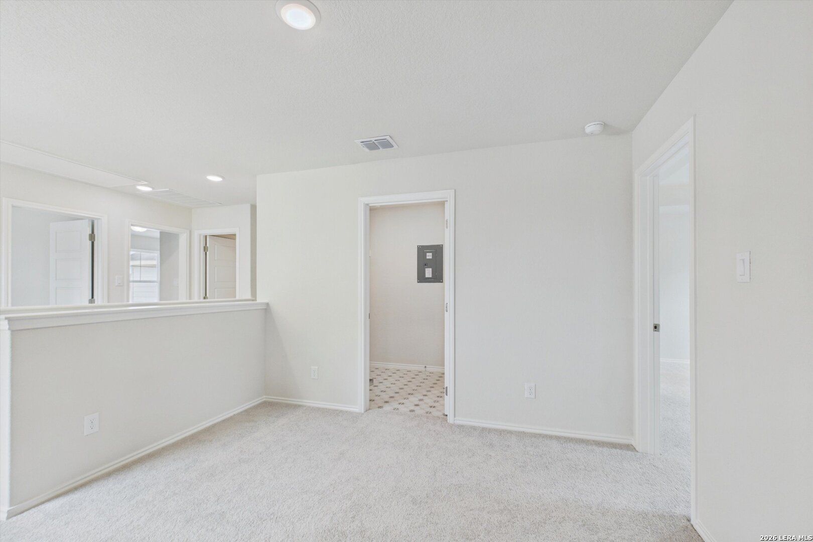 Bright carpeted loft area in The Charlotte B floor plan at Meadows at Oak Creek, San Antonio, Texas.