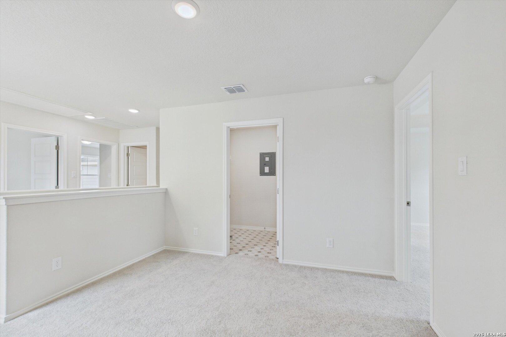 Bright carpeted loft area in The Charlotte B floor plan at Meadows at Oak Creek, San Antonio, Texas.