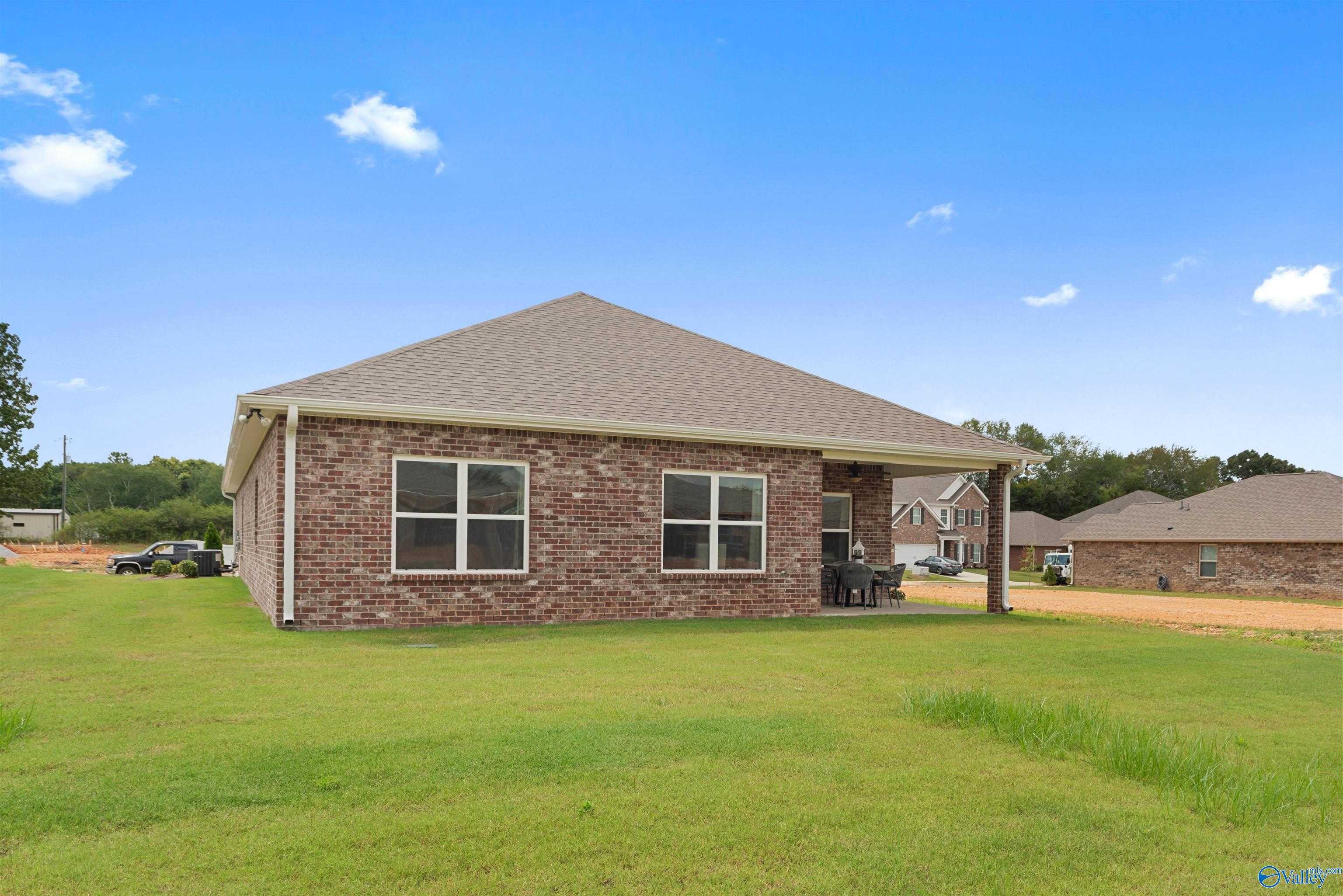 Single-story brick Everett home exterior with windows, covered porch, and green lawn in Flint Meadows, New Market, Alabama
