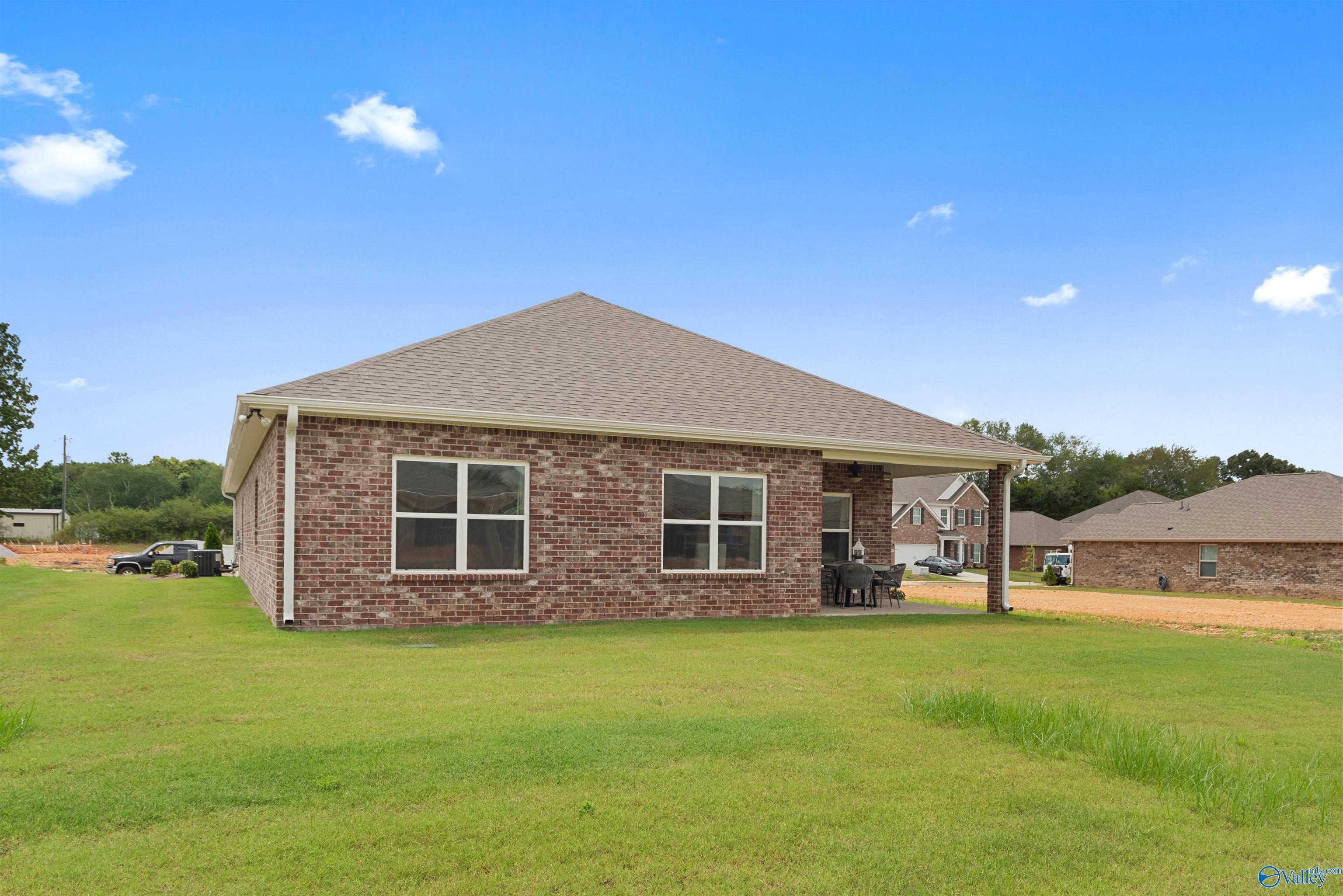 Single-story brick Everett home exterior with windows, covered porch, and green lawn in Flint Meadows, New Market, Alabama