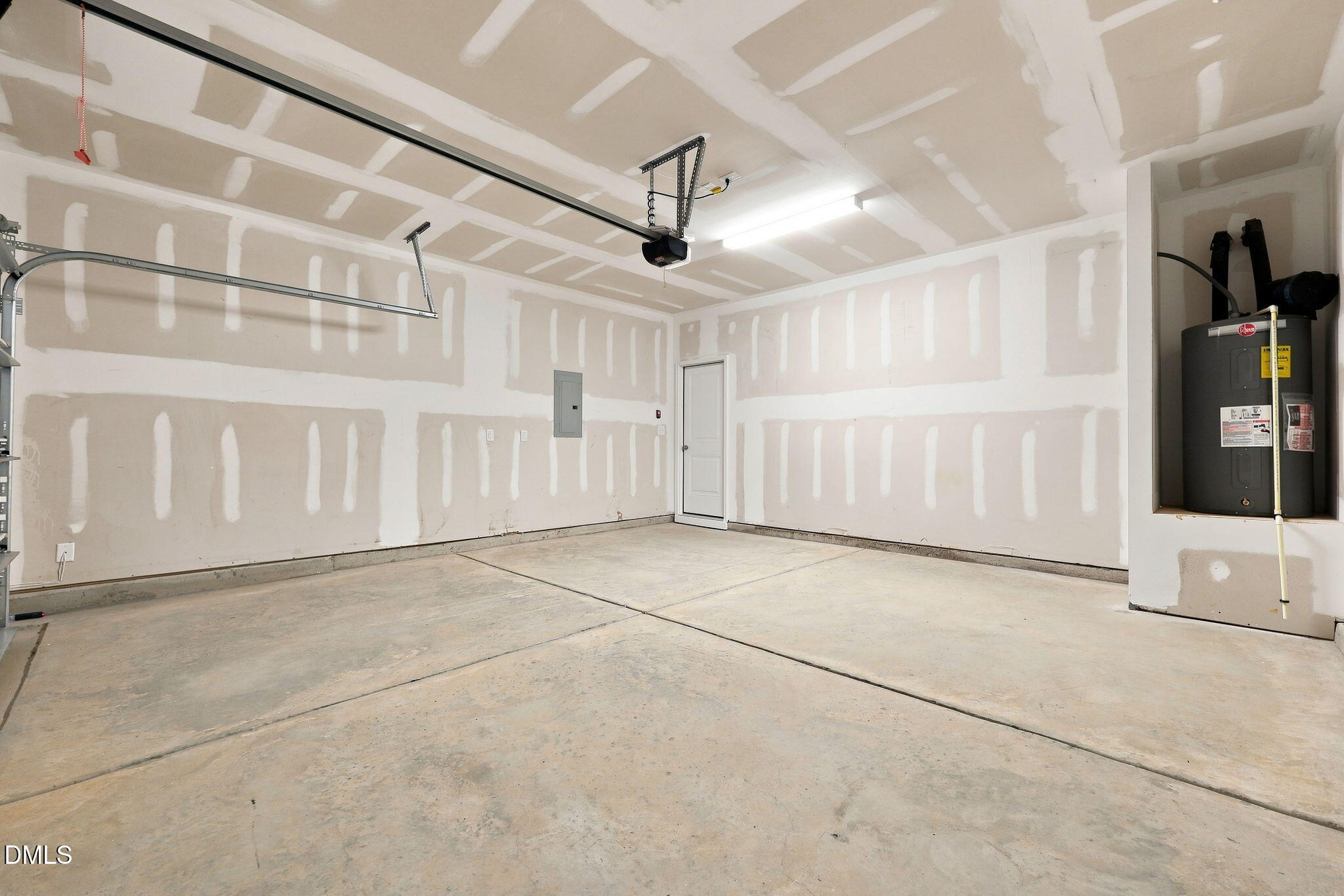 Unfinished 2-car garage with drywall and water heater in The Magnolia B floor plan at Retreat at North Main, Lillington, NC.