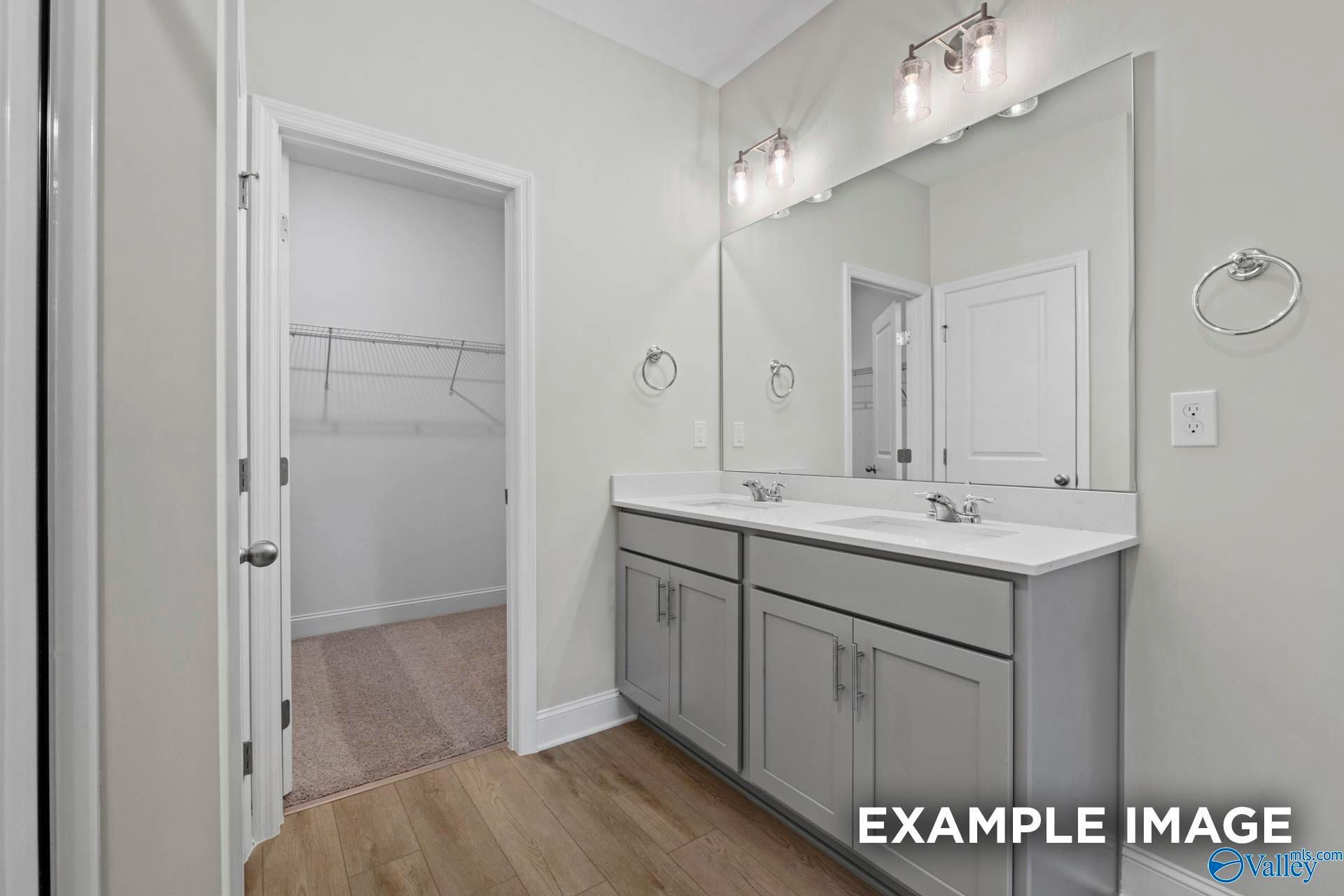 Dual vanity bathroom with gray cabinets and walk-in closet in The Franklin C floor plan at Noble Ridge, Cullman, Alabama.
