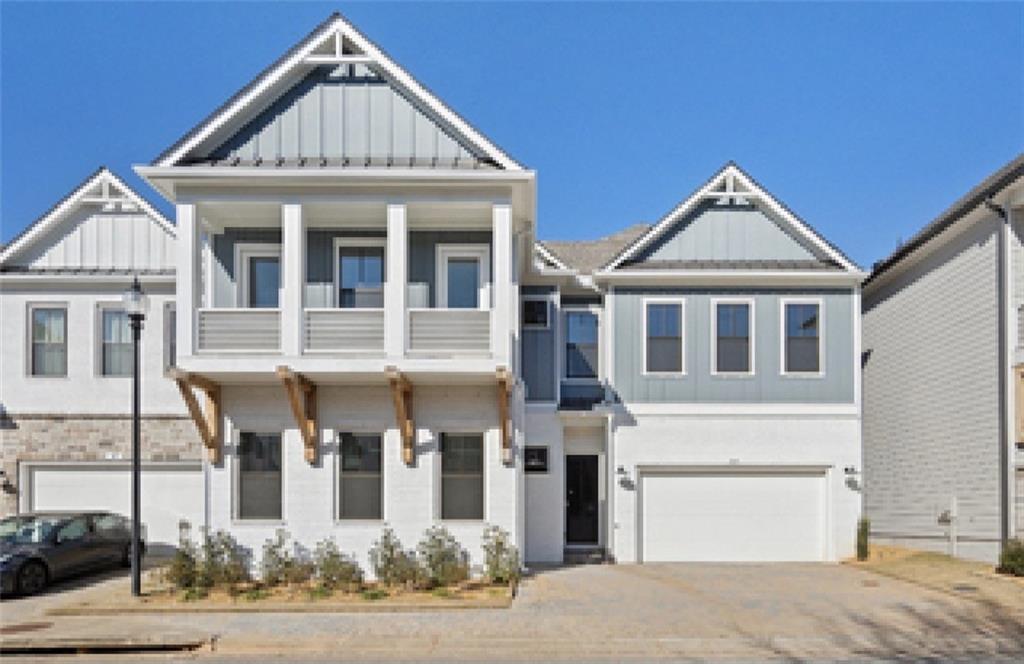 Two-story Seaside A home exterior with balcony, three-car garage, and craftsman siding in The Village at Towne Lake, Woodstock, Georgia