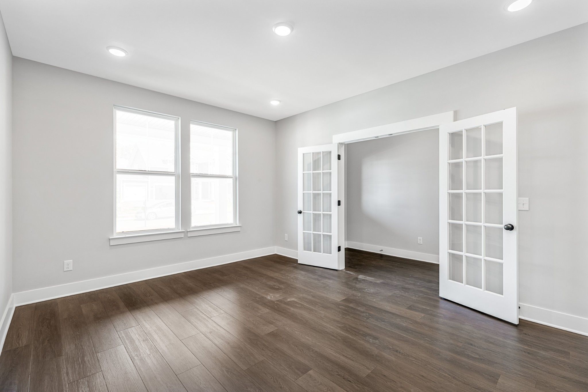 Bright formal dining room with open French doors, large windows, and hardwood floors in Davidson Homes The Henry C, White House, TN