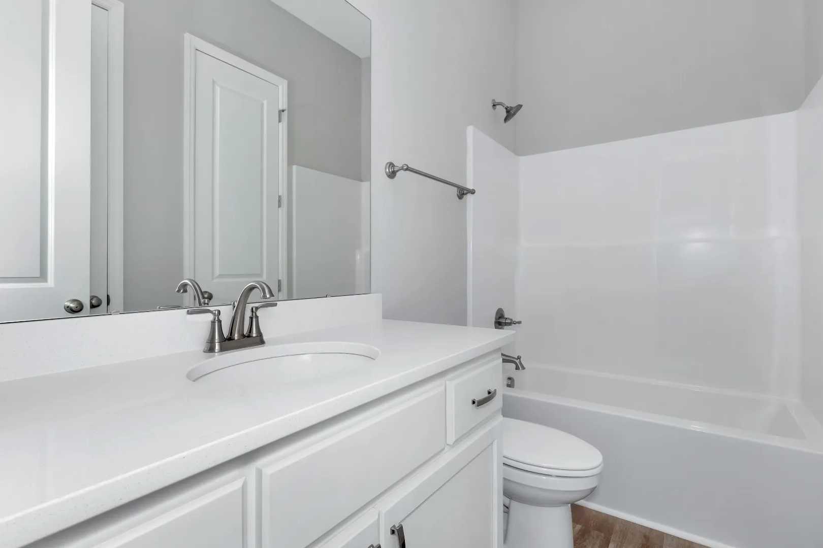 Spacious white bathroom in The Arcadia M featuring double sink vanity, soaking tub, shower combo, and modern fixtures