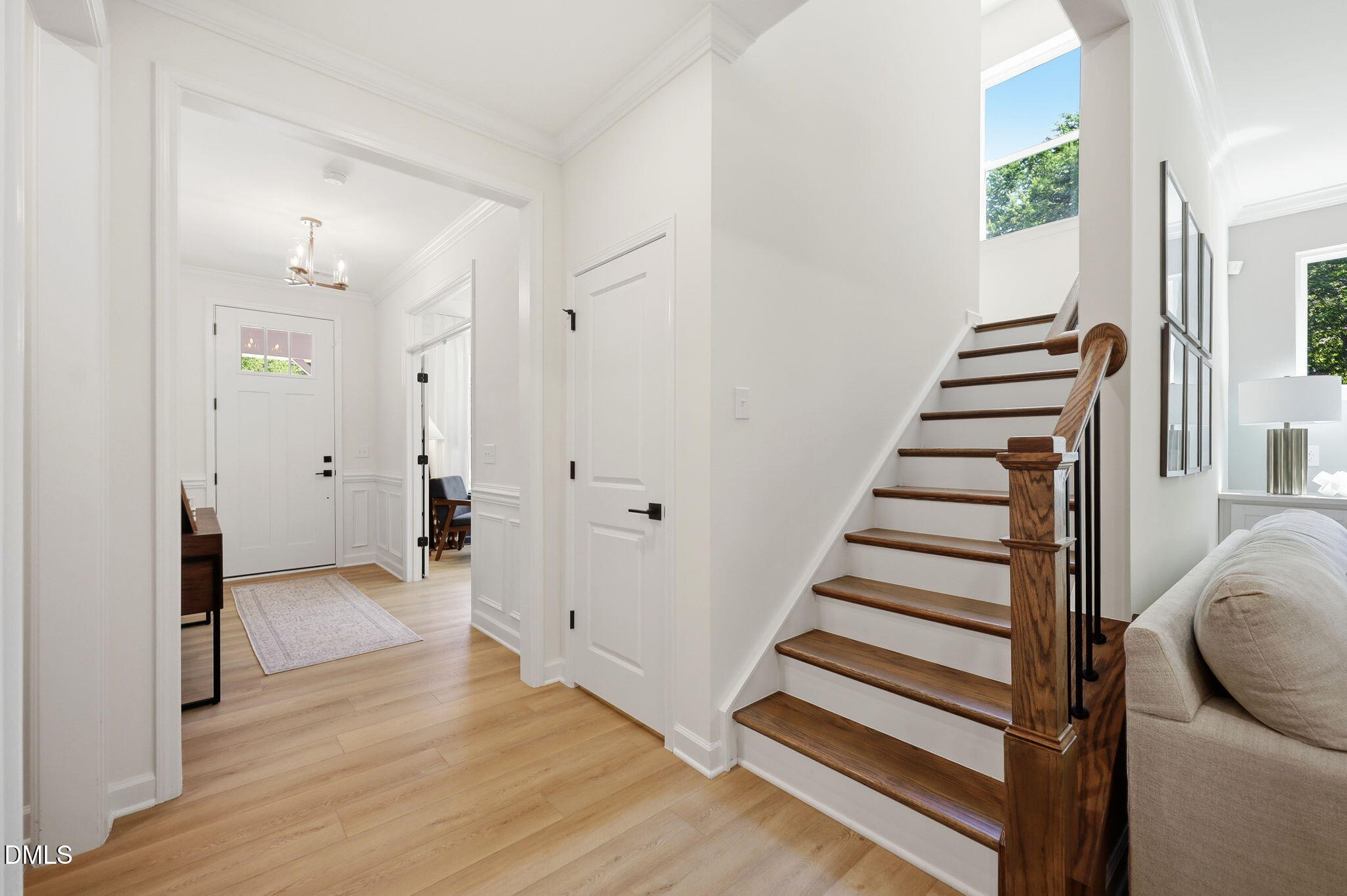 Bright entryway with hardwood floors and wooden staircase in The Aspen B floor plan by Davidson Homes in Wendell, NC.